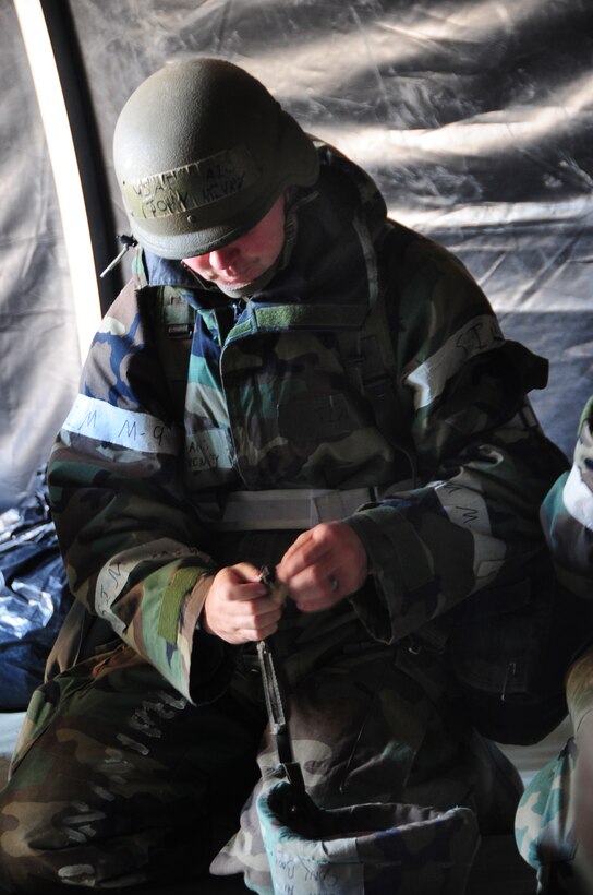 ELLSWORTH AIR FORCE BASE, S.D. - Airman 1st Class John Henry, 28th Medical Support Squadron medical technician, assists other medical Airmen with their gear at Camp Lancer during a Phase II Operational Readiness Inspection, Oct. 14.  During a Phase II ORI, AIrmen are pu through tests that assess their skills and abilities in a deployed environment. (U.S. Air Force photo/Airman 1st Class Anthony Sanchelli)