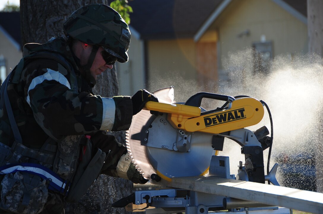 ELLSWORTH AIR FORCE BASE, S.D. - Staff Sgt. Jeremiah Messimer, 28th Civil Engineer Squadron structural craftsman, uses a hand-held saw to cut out pieces for a drop arm gate at Camp Lancer during a Phase II Operational Readiness Inspection, Oct. 14.  28 CES Airmen stay on top of their skills and abilities during the Phase II ORI during a simulated deployed environment. (U.S. Air Force photo/Airman 1st Class Anthony Sanchelli)