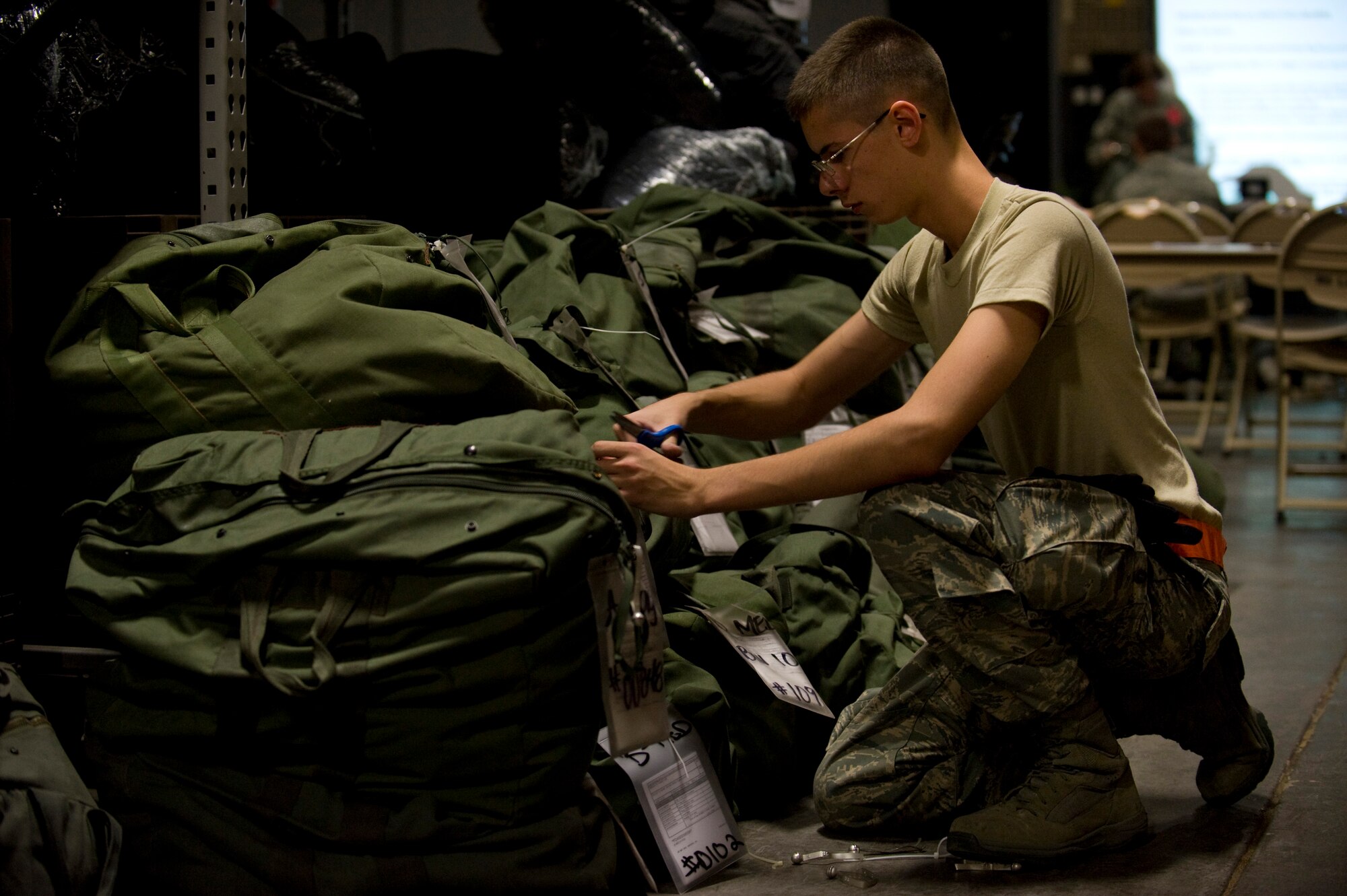 NELLIS AIR FORCE BASE, Nev. -- Airman William Roberts, 99th Logistics Readiness Squadron material management specialist, replaces tags on his mobility bags during the Operational Readiness Exercise Oct. 13. The ORE tests the 99th Air Base Wing’s ability to implement increased security procedures, gain 100 percent accountability of all Airmen, prepare the wing for quick deployment and continue with daily operations that help accomplish the Air Force mission. (U.S. Air Force photo by Senior Airman Brett Clashman/Released)