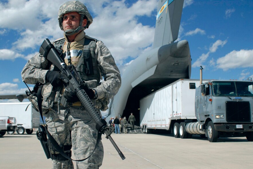 Capt. James Spindler secures the perimeter as equipment is loaded into a C-17 Globemaster III at Peterson Air Force Base, Colo., Oct.5, 2010. Captain Spindler is the mobile operation unit director of operations for the 4th Space Operations Squadron. (U.S. Air Force photo/Senior Airman Erica Picariello)