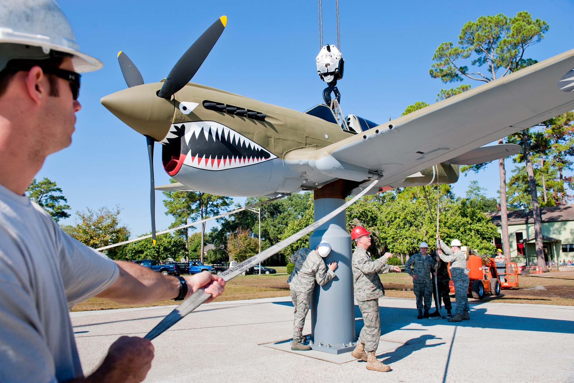 MOODY AIR FORCE BASE, Ga -- Members of the 23rd Equipment Maintenance Squadron position a P-40 Warhawk on an aircraft display stand Oct. 14 at what will soon be Moody's Heritage Park. The P-40 is the fourth aircraft to call the park home. Earlier this month, the 23rd EMS moved an A-7D Corsair II, F-105 Thunderchief and A-10 Thunderbolt II there for display. (U.S. Air Force photo/Senior Airman Jamal D. Sutter)