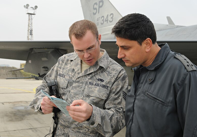 GRAF IGNATIEVO AIR FORCE BASE, Bulgaria - Staff Sgt. Joshua Adcock, 52 Aircraft Maintenance Squadron avionics systems journeyman, and his Bulgarian counterpart, Capt. Pavlin Novakov, review an F-16 Fighting Falcon maintenance analysis card during Operation Thracian Star Oct. 13. Captain Novakov was one of six Bulgarian air force maintainers to learn about U.S. Air Force procedures in weapons, avionics, electronics, and engine maintenance career fields. (U.S. Air Force photo/Staff Sgt. Benjamin Wilson)