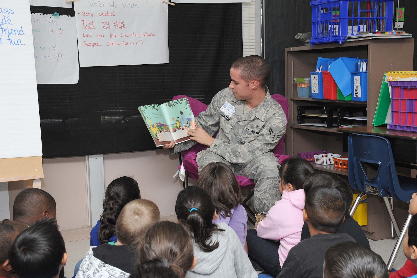 Airman 1st Class Curtis Lawson, 59th Radiology Squadron, reads a story to children at Valley Hi Elementary Oct. 7. Airman Lawson was among 65 Joint Base San Antonio members, including servicemembers and civilians, who participated in the quarterly program to read to children in schools surrounding JBSA installations. (U.S. Air Force photo/Alan Boedeker)
