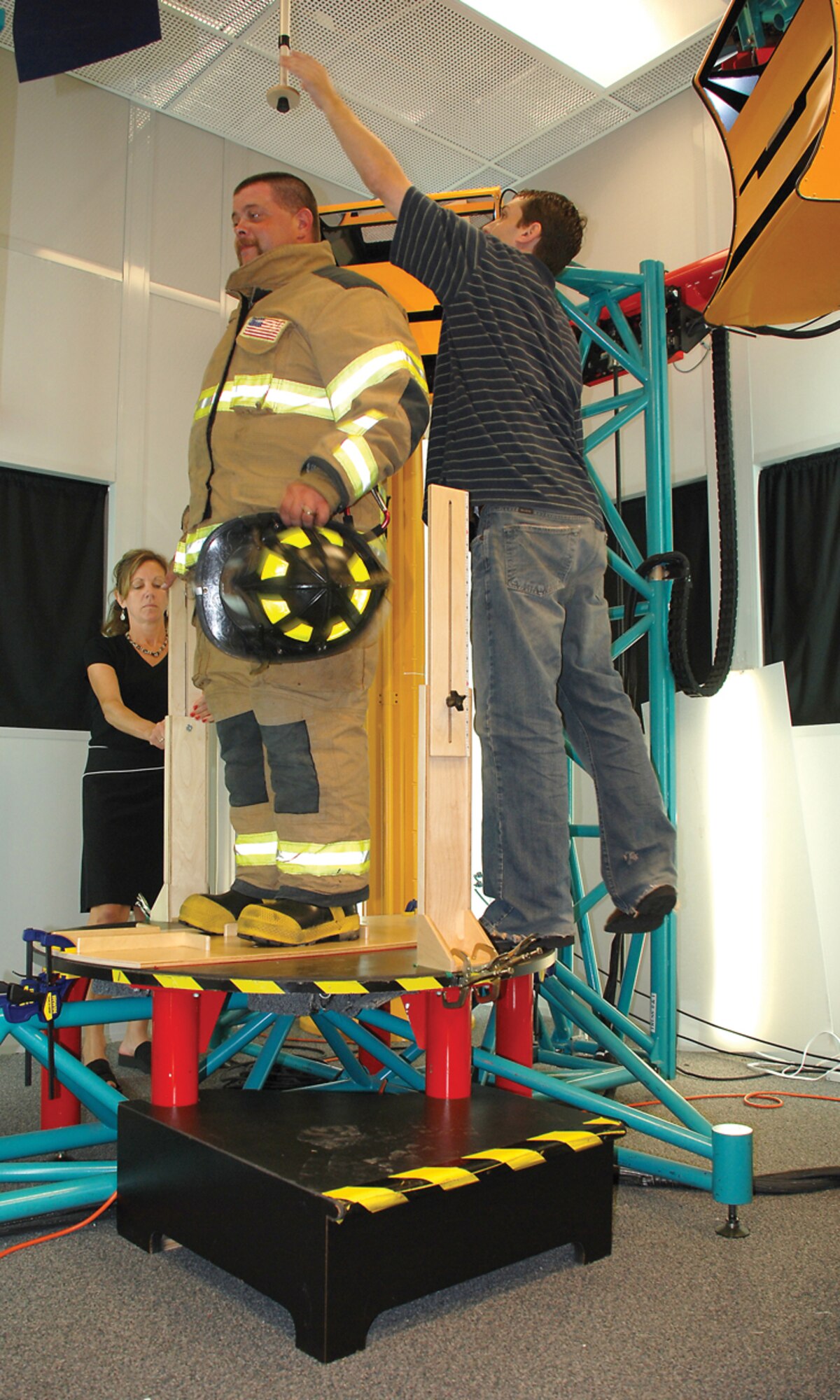 An anthropometry specialist prepares a firefighter test subject (dressed in full turnout gear) for a three-dimensional scan at AFRL's Computerized Anthropometric Research and Design laboratory. (Air Force photo by Chris Gulliford, 711 HPW)
