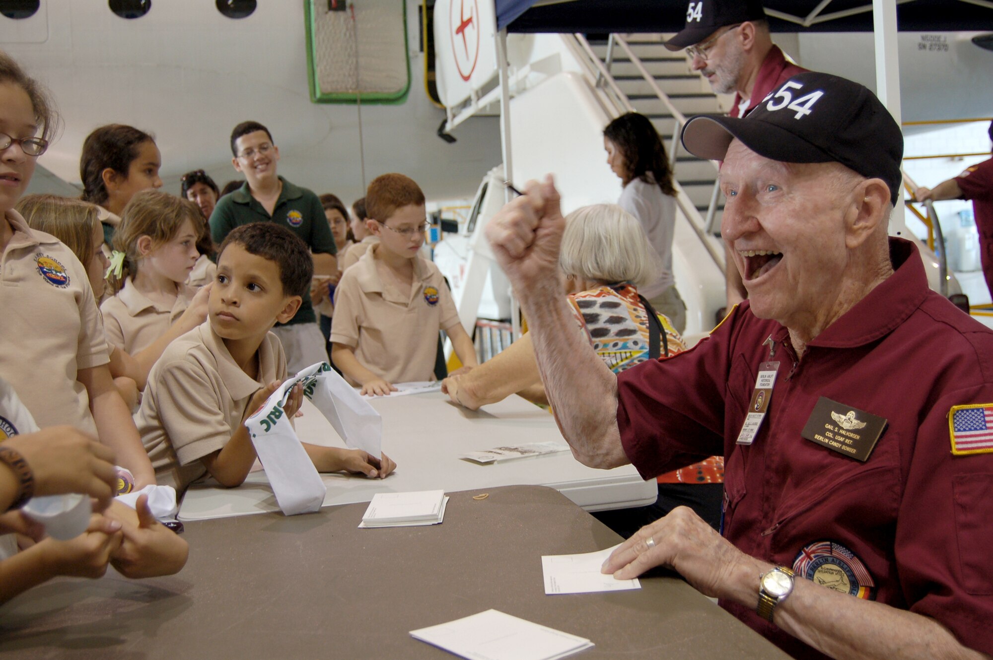 Retired Col. Gail Halvorsen signs autographs for children in Puerto Rico at one of his annual visits. Colonel Halvorsen, also known as the Berlin Candy Bomber, flew C-54 Skymasters during the Berlin Airlift and parachuted candy to children from his airplane. (U.S. Air Force photo/Tech. Sgt. Ben Gonzales)