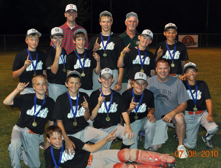 Master Sgt. Trevor Parson (front row, second to last on the right), 319th Force Support Squadron manpower superintendent, poses for a picture with his 2010 youth baseball team that he coaches after the team won their championship game. (Courtsey photo)