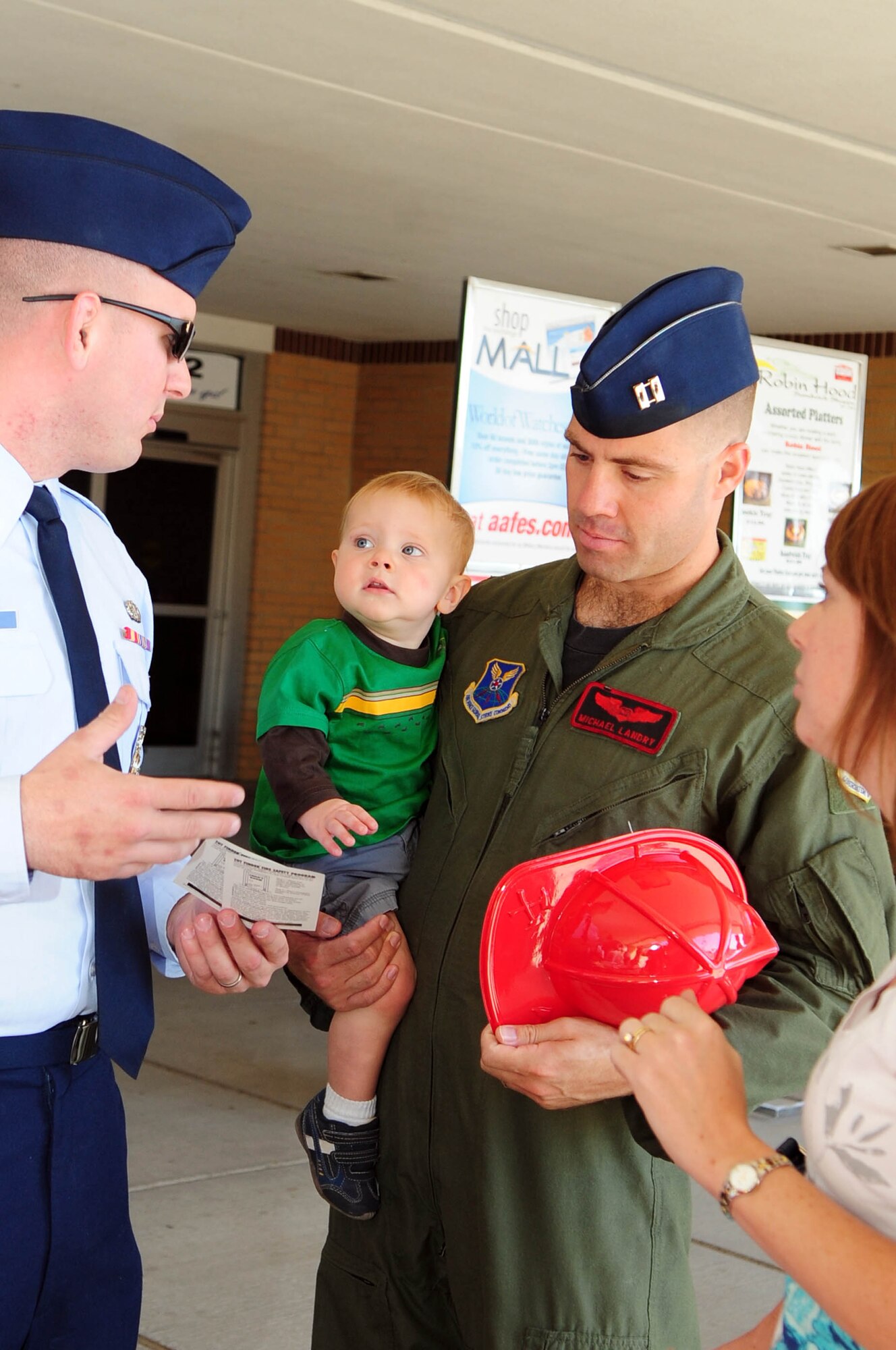 BARKSDALE AIR FORCE BASE, La. -- A member of the Barksdale Fire Department instructs Capt. Michael Landry and his family how to properly use a 'tot finder' sticker during Fire Prevention Week outside the Barksdale Base Exchange Oct. 7. A 'tot finder' is placed outside of a child's room so firefighters can locate them inside a home where fire or smoke is present. Tot finders were previously placed outside the home on the child's window, but are now placed below the door handle on the outside of the child's bedroom door. (U.S. Air Force photo by Senior Airman Joanna M. Kresge)