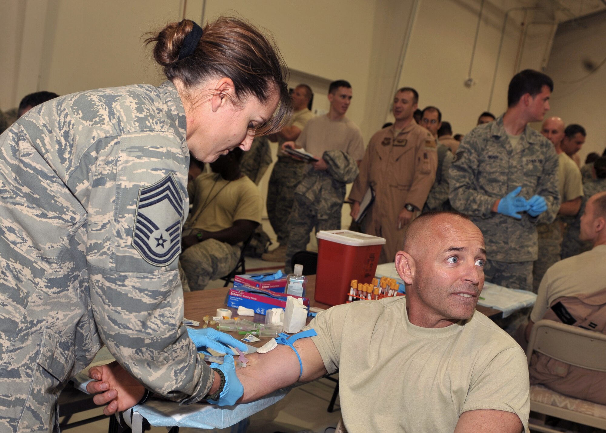 CANNON AIR FORCE BASE, N.M.--Chief Master Sergeant Stephanie Powell, 27th Special Operations Medical Group Superintendent, draws blood from Chief Master Sergeant Jackie Powell, 27th Special Operations Maintenance Group Superintendent, in Hangar 196 October 5.  Both husband and wife were deployed in different locations, but were able to come back together.  (U.S. Air Force photo by Senior Airman James Bell)