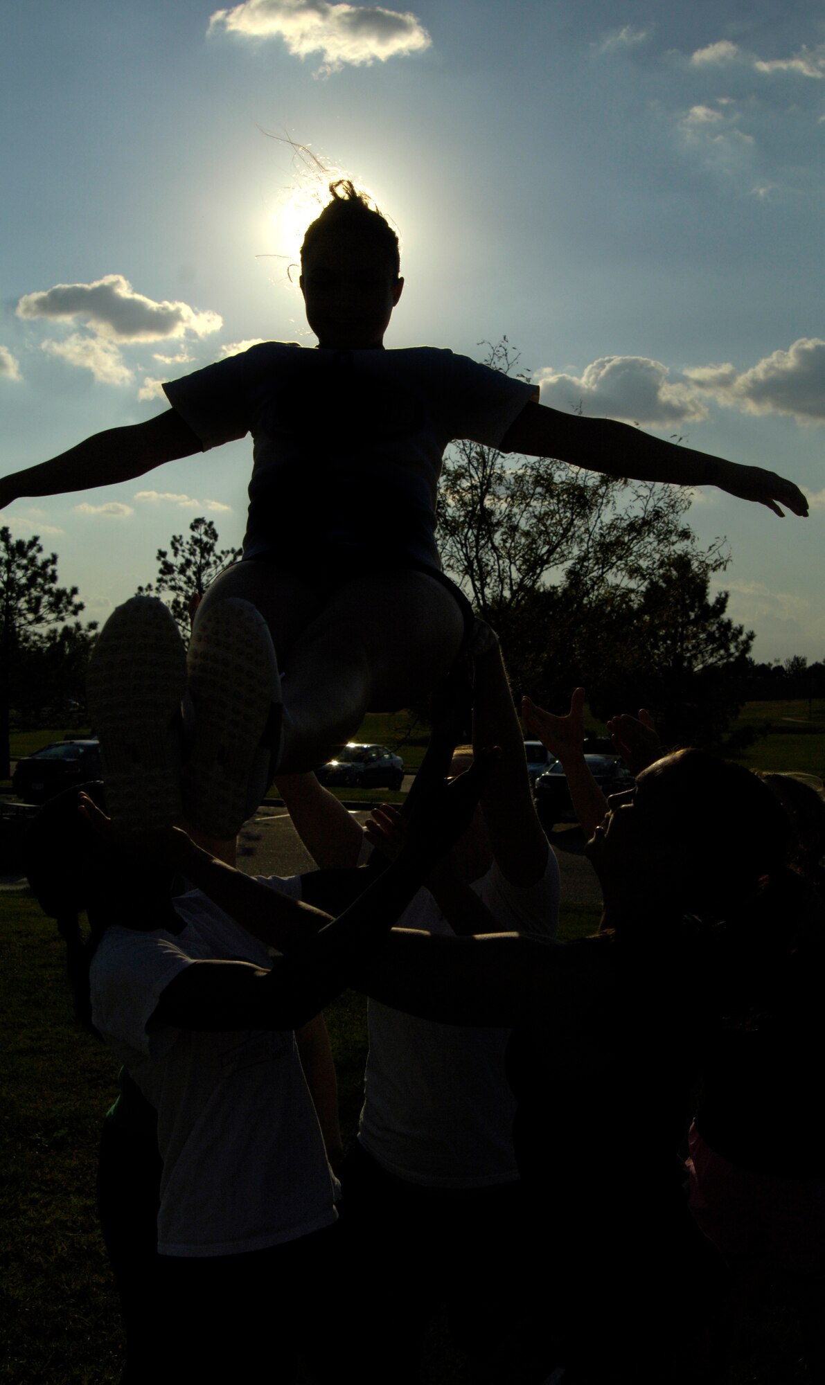 Airman 1st Class Baily Zimmerman, 22nd Aerospace Medicine Squadron flight medicine technician, practices a cradle stunt Oct. 12, 2010, McConnell Air Force Base, Kan. Airman Zimmerman and the McConnell cheerleaders are preparing to cheer for McConnell’s flag football game against Fort Riley Soldiers. The game is scheduled for Oct. 16 at Fort. Riley, Kan. The coach, players and cheerleaders request the participation of Team McConnell. (U.S. Air Force photo/Airman 1st Class Armando A. Schwier-Morales)