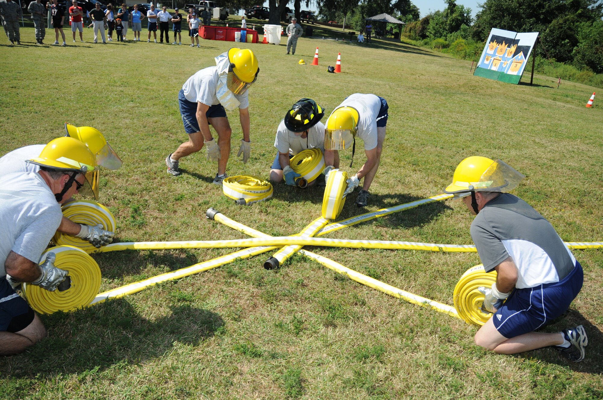 Members of the chapel's Holy Fire Squad work together in the hose roll competition at the Oct. 8 fire muster.  The team won second place overall.  (U.S. Air Force photo by Kemberly Groue)