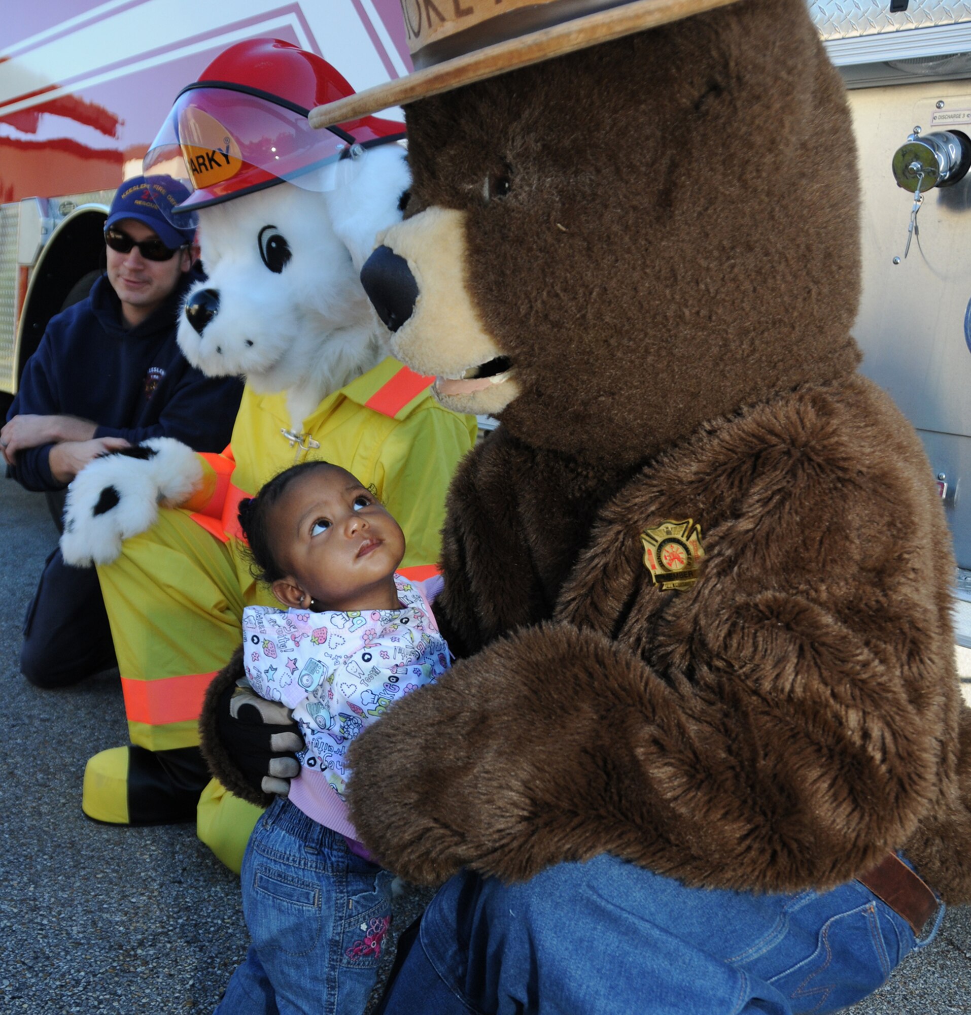 From left, Keesler firefighter Daniel Fish and Sparky the Fire Dog look on as 1-year-old Shaelyn Moore casts a wary glance at Smokey the Bear during the fire department’s visit to the child development center Oct. 5. Shaelyn’s parents are Senior Airman Dimaris Moore, 81st Inpatient Operations Squadron, and Staff Sgt. Jason Moore, 81st Security Forces Squadron.  (U.S. Air Force photo by Kemberly Groue)