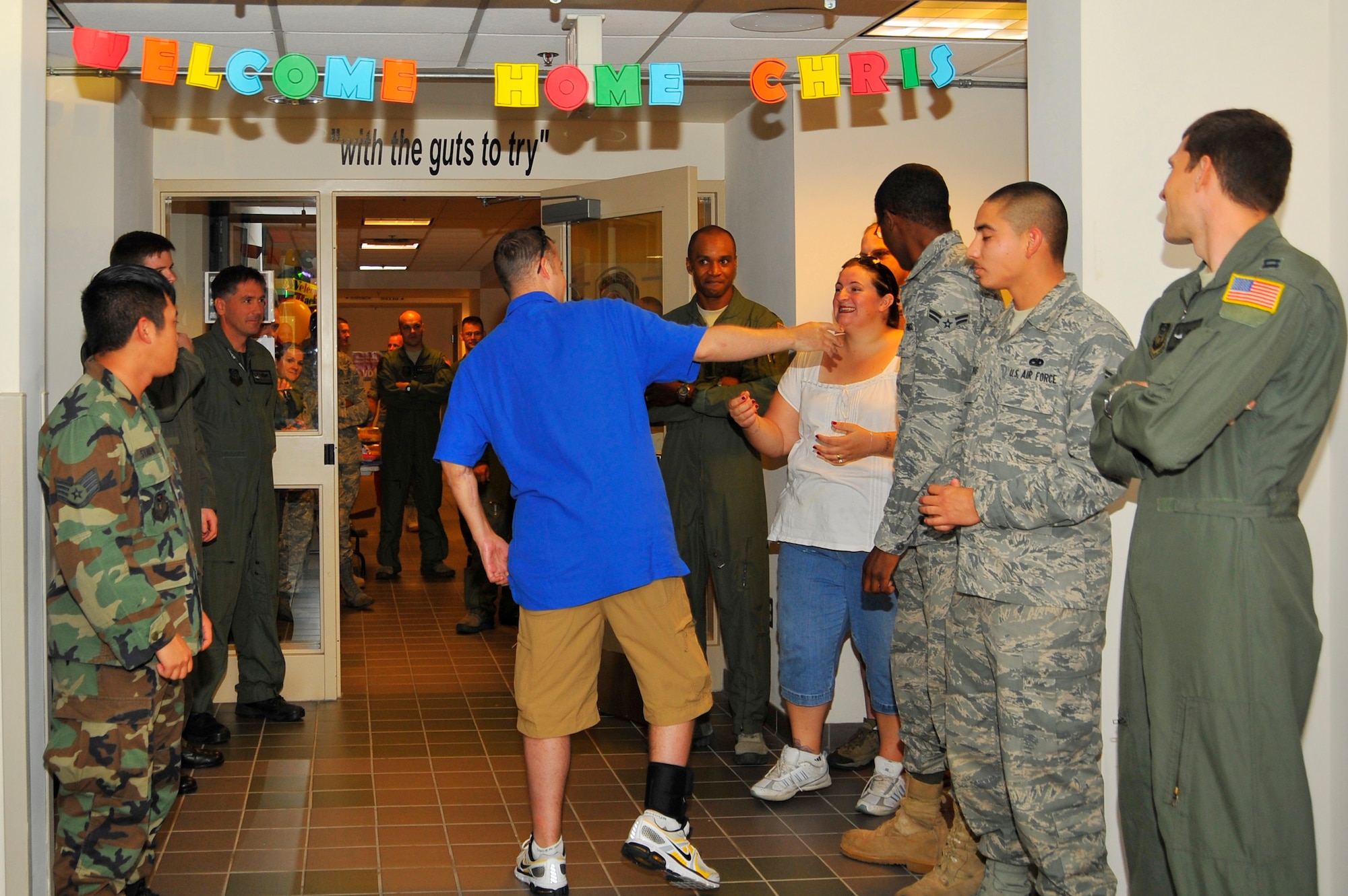 U.S. Air Force Staff Sgt. Chris Curtis, 8th Special Operations Squadron, is greeted by squadron members and friends after triumphantly walking through the doors of the 8th SOS Oct. 8, 2010.  Sergeant Curtis was a flight engineer on an 8th SOS CV-22 Osprey that crashed in Zabul province, Afghanistan April 8, 2010 leaving him with significant blood loss and multiple fractures to his back, face, both legs, left arm and pelvis.  The goal of walking through his squadron on his own accord was a motivating factor in Sergeant Curtis' recovery. (DoD photo by U.S. Air Force Senior Airman Sheila deVera/RELEASED)