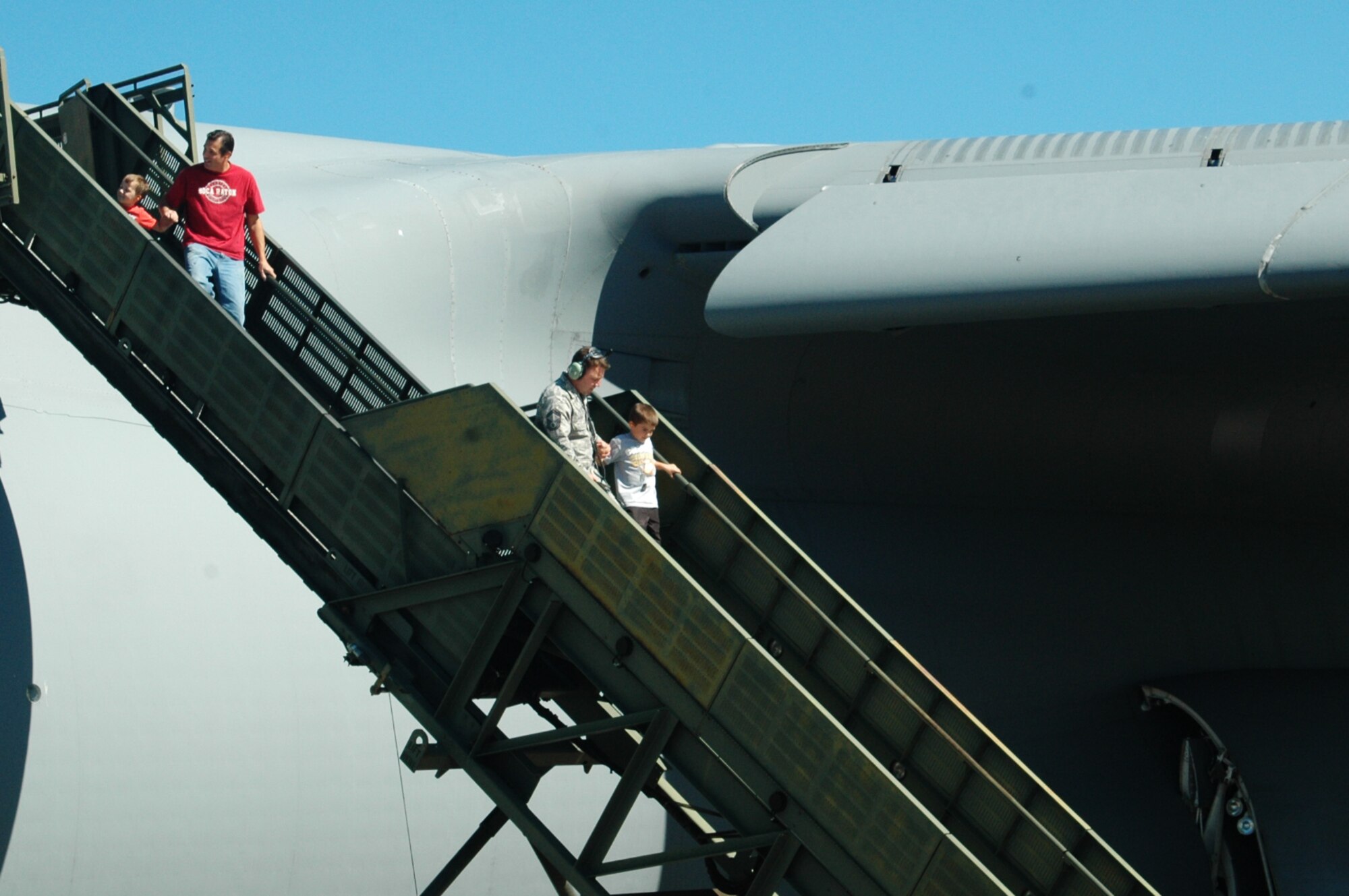 Brandon Hanechak, honorary 337th Airlift Squadron C-5 pilot, comes down from the flight deck of a C-5, accompanied by Senior Master Sgt. Todd Ramsey, Oct. 2.  Brandon came to Westover as part of the Pilot for a day program that recognizes children who have faced serious medical issues with courage
