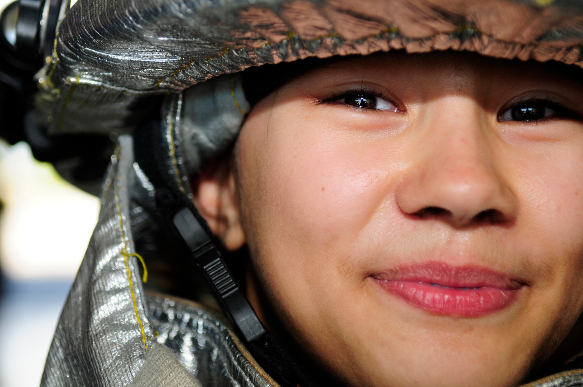 Christina Gregory, Junior Reserve Officer Training Corps student at Aviano High School and daughter of Master Sgt. Craig Gregory, Air Force Smart Operations for the 21st Century, tries on firefighter safety gear during a tour of Aviano Sept. 29. The J-ROTC group toured the fire station, the 555th Fighter Squadron, the American Forces Network station, and saw a military working dog demonstration. The tour was meant to show prospective future Air Force members different aspects of a varied Air Force mission. (U.S. Air Force photo by Airman 1st Class Katherine Windish)