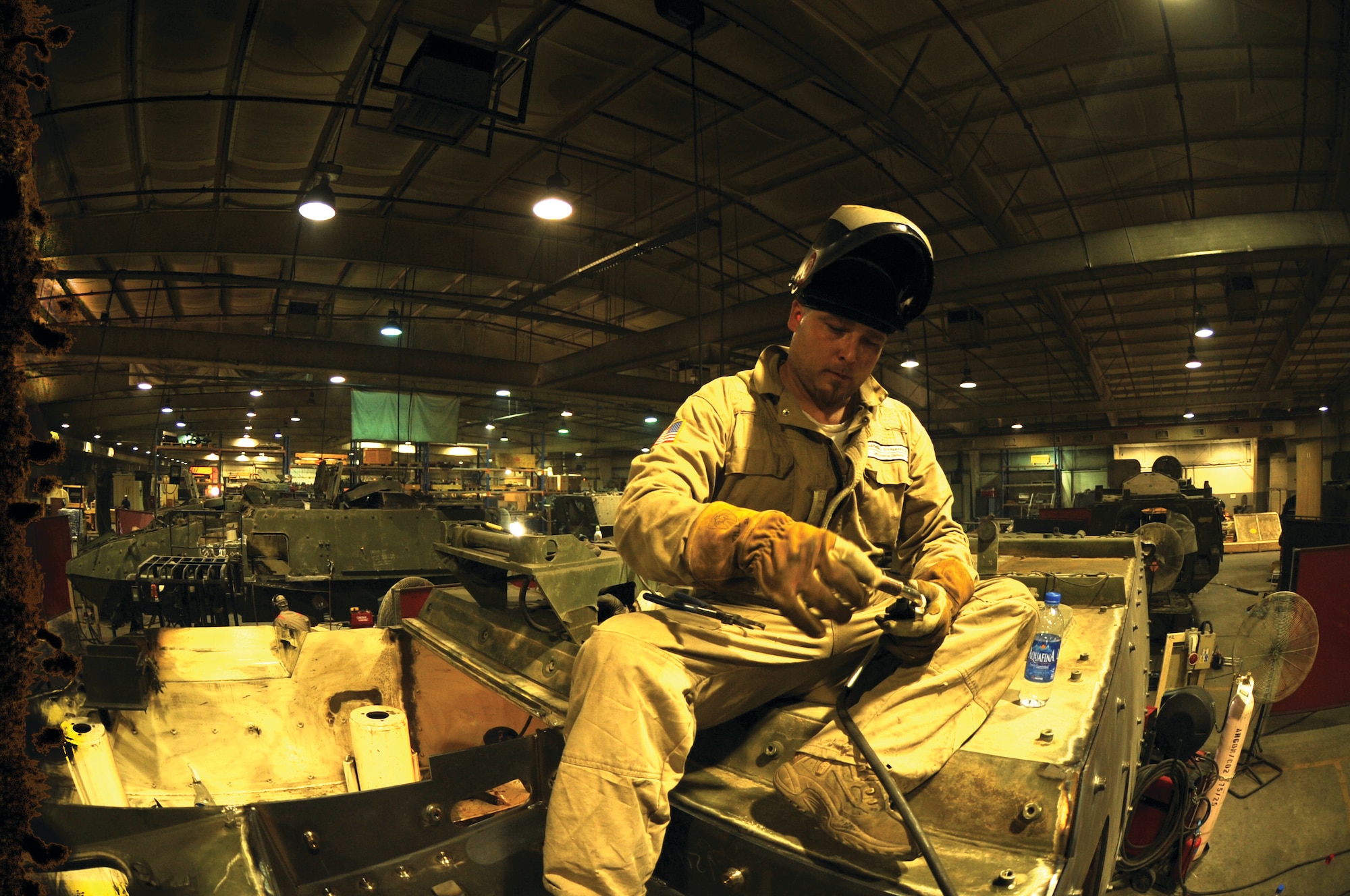 Jason Hill, a senior welder at General Dynamics Land Systems Battle Damage Repair Facility at Camp As Saylayah in Southwest Asia, works on welding a damaged Stryker recently. The welders at the BDRF complete all welding by hand to rebuild battle-damaged Strykers for return to the battlefield.(U.S. Air Force photo/Staff Sgt. Tim Jenkins)