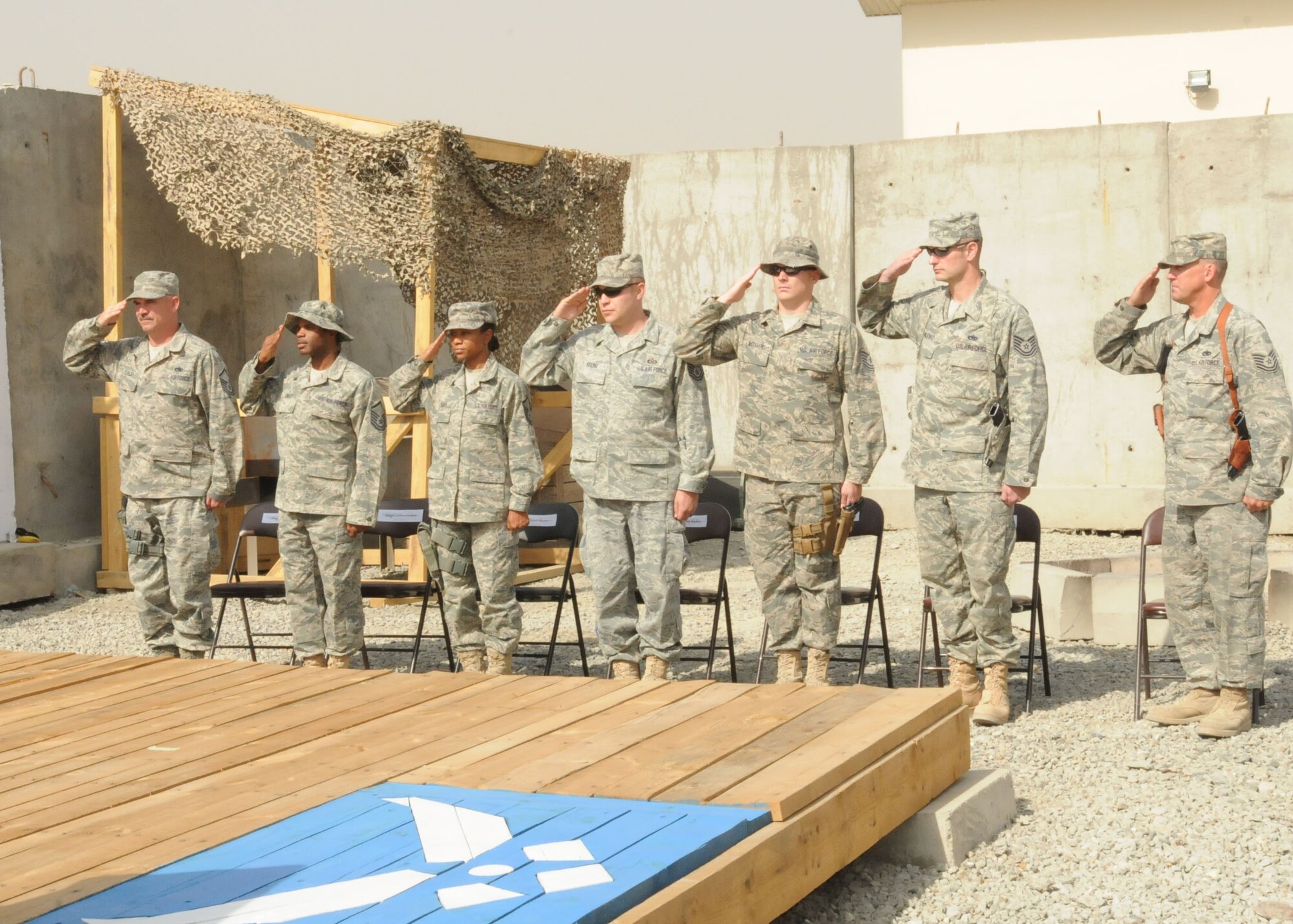 Kabul, Afghanistan - The 438th AEW honored the seven inductees in the 2010 Senior NCO Induction Ceremony on Oct 14. The selectees salute the American flag during the beginning of their capping ceremony. (U.S. Navy photo by Mass Communications Specialist 3rd Class Jared E. Walker / RELEASED).