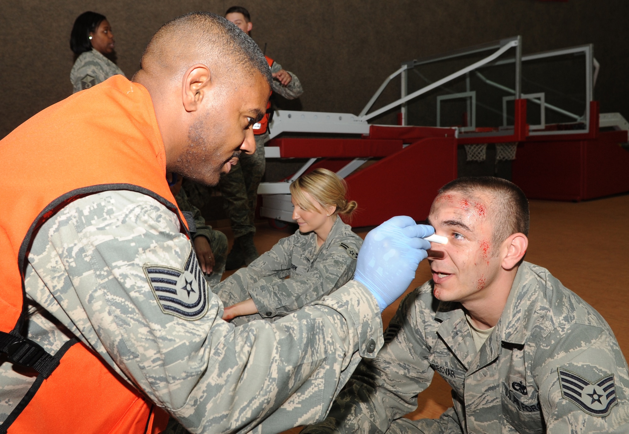 SPANGDAHLEM AIR BASE, Germany – Tech. Sgt. Jamarlon Waller, left, 52nd Medical Operations Squadron, NCO in charge of ambulance services, treats a moulage victim with scratches during an exercise Oct. 12. The exercise evaluated the wing’s ability to respond to a major accident involving mass casualties. (U.S. Air Force photo/Senior Airman Nick Wilson)