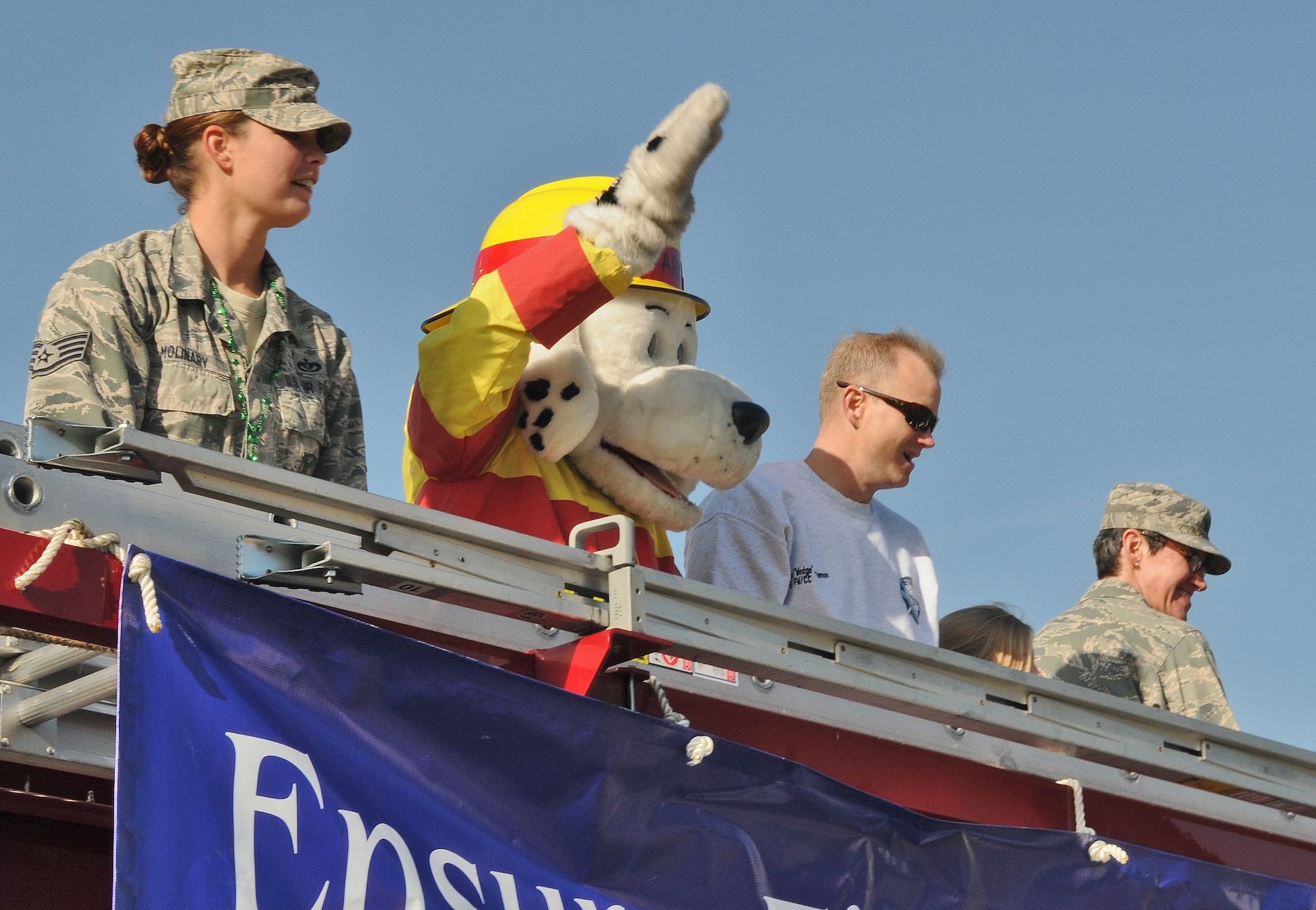 SPANGDAHLEM AIR BASE, Germany – Staff Sgt. Crystal Molinary, 52nd Civil Engineer Squadron, Sparky the fire safety dog, Col. Christopher Weggeman, 52nd Fighter Wing commander, and Col. Jodine Tooke, 52nd Mission Support Group commander, wave to Sabers during a fire brigade parade of German and U.S. fire trucks through Spangdahlem’s housing loop as part of Fire Prevention Week  Oct. 9.  The day also included fire emergency services activities such as an auto extrication demonstration, U.S. and German fire truck static displays, hose bowling, bunker drills, a smoke house, stove safety and a free barbecue. Since 1922, Fire Prevention Week has taken place in the U.S. to increase fire safety awareness. (U.S. Air Force photo/Senior Airman Nick Wilson)