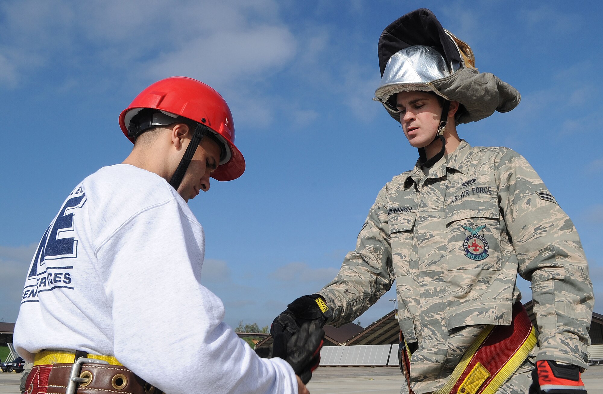 SPANGDAHLEM AIR BASE, Germany – Airman 1st Class Austin Cooner, left, 52nd Operations Support Squadron “Angry Chickens” fire muster team member, puts on safety equipment with assistance from Airman 1st Class Steven Vandenburg, 52nd Civil Engineer Squadron firefighter, during Spangdahlem’s first ever Fire Muster Challenge as part of Fire Prevention Week Oct. 9. Since 1922, Fire Prevention Week has taken place in the U.S. to increase fire safety awareness. (U.S. Air Force photo/Senior Airman Nick Wilson)