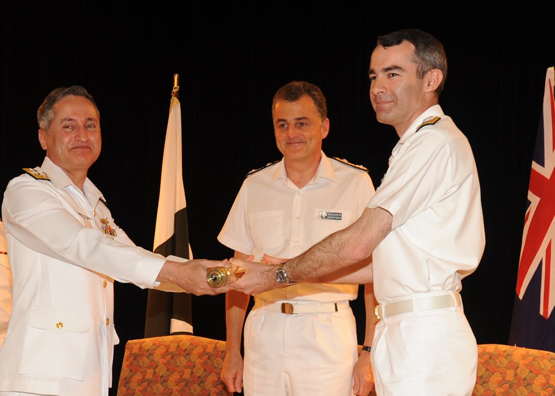 Pakistan navy Rear Adm. Zafar Mahmood Abbasi, outgoing Combined Task Force 150 commander, left, passes a ceremonial scroll to incoming commander Royal Australian navy Commodore Gregory Sammut during a change of command ceremony in Manama, Bahrain, Oct. 14, 2010. Abbasi assumed command of CTF-150 on April 15, 2010. The task force is responsible for conducting maritime security operations in the Gulf of Aden, the Gulf of Oman, the Arabian Sea, the Red Sea and the Indian Ocean. U.S. Navy photo by Chief Petty Officer David Sidney