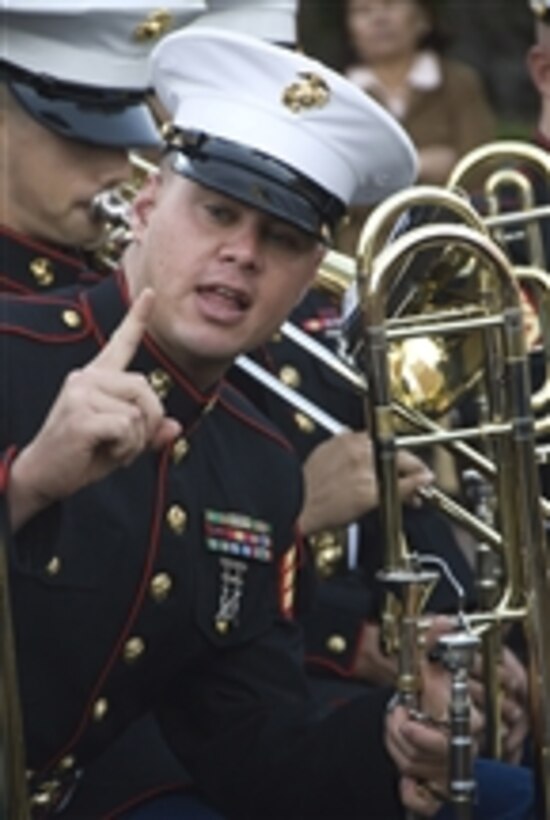 U.S. Marine Corps Sgt. Juan Fernandez, with the 1st Marine Division Band, talks to a band mate during a concert in Huntington Park, Calif., on Oct. 9, 2010.  The concert was held as part of San Francisco Fleet Week 2010.  San Francisco Fleet Week 2010, which will feature more than 3,000 sailors, Marines and Coast Guardsmen, is designed to give the military sea services an opportunity to showcase their operational capabilities.  