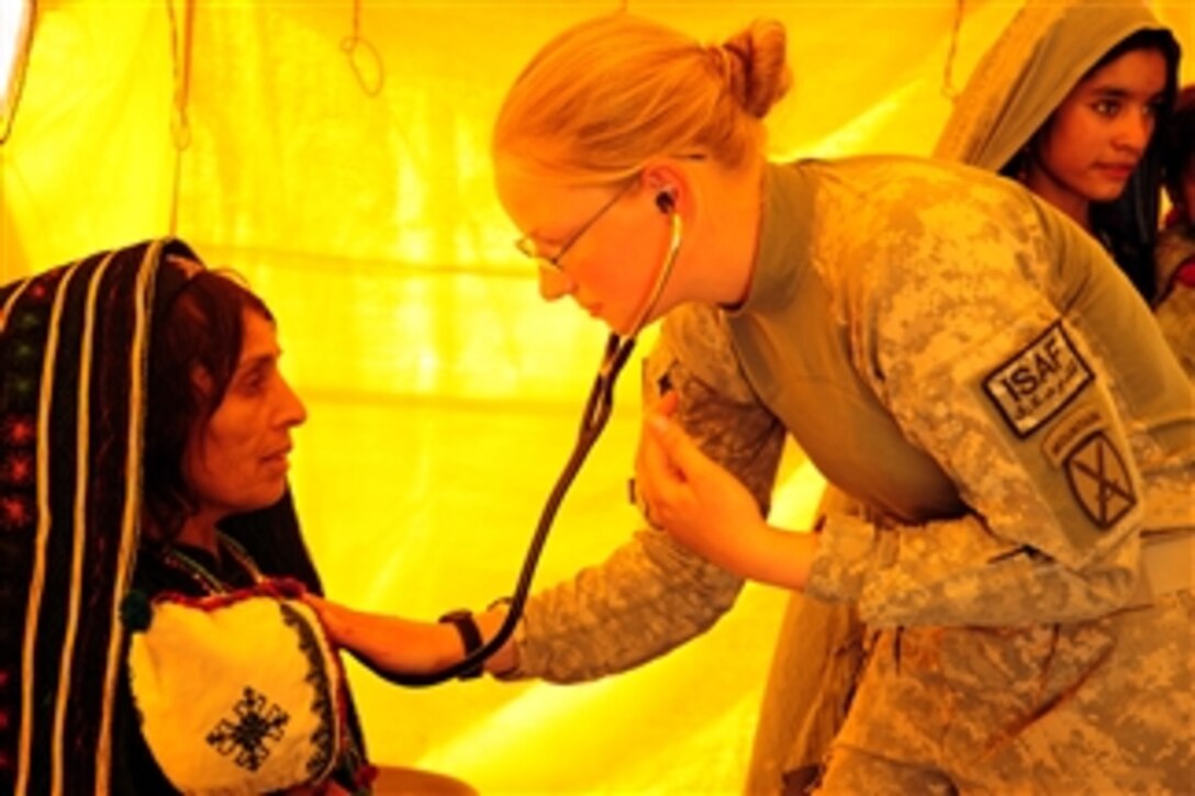 Spc. Margie Huelskamp, a medic attached to 3rd Battalion, 6th Field Artillery of the 10th Mountain Division’s 1st Brigade Combat Team, listens to the heartbeat of a local woman at the Ghormach Clinic during a medical mission on Oct. 2, 2010.  Over two days, more than 400 people from throughout the Ghormach District were seen by two medical providers and seven medics from 1st Brigade Combat Team.  