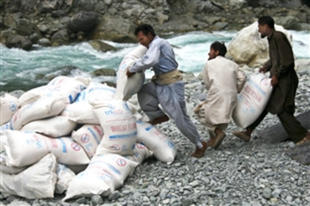 Pakistanis unload relief supplies from a U.S. Army CH-47 Chinook helicopter in Khyber Pakhtunkhwa province, Pakistan, Oct. 9, 2010. The U.S. military is providing relief assistance and food to victims of flood-damaged areas.