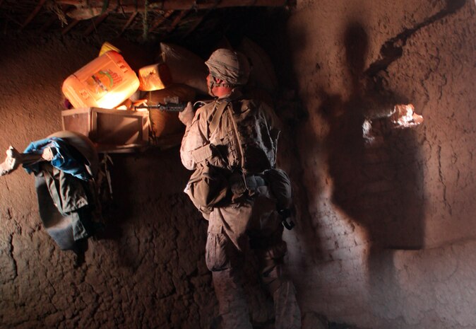 Pfc. Mack Thornton, an infantryman with Company A, 1st Bn., 8th Marines, inspects yellow jugs and assorted articles, during a search for improvised explosive device components and other illicit material in the town of Deh Kerez, Oct. 13. Over several days, Marines and sailors with 1st Bn., 8th Marines, supported the Afghan National Army and Afghan National Police, in a joint operation to secure the town of Deh Kerez, expanding the area controlled by the Afghan government, east of Musa Qal’eh.