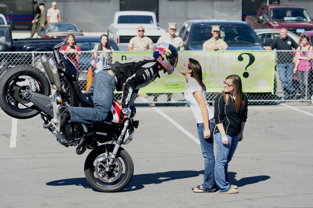 Aaron Colton, a freestyle street bike exhibitionist for Red Bull, executes a maneuver with a Red Bull promotional girl during the 3rd annual Hadnot Point Annex Customer Appreciation Day aboard Marine Corps Base Camp Lejeune, Oct.15. World-renowned wrestler Ric Flair also made an appearance, stunning fans and adding to the hype as military personnel and civilians treated themselves to free food and drinks, courtesy of the annex's vendors.