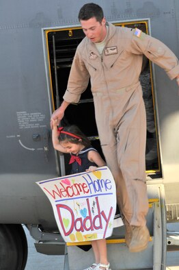 PATRICK AIR FORCE BASE, Fla. - 1st Lt. Patrick Woodruff, HC-130P/N King pilot, 920th Rescue Wing here, is led by his daughter, Ella, 5, out the side of the aircraft which he just landed October 15, 2010, after piloting it, with a crew of 5, all from Africa to Florida with 20 Airmen aboard. His wife, Lauren, and black labrador retriever, Belle, were also there to greet Lt. Woodruff. The Air Force Reservists were deployed to the horn of Africa region were they provided combat search and rescue support. All together 63 Reservists were deployed for 45 days. The Wing is one of the most called upon units in the nation. Rescue Wing Airmen deploy often supporting combat search and rescue worldwide. (U.S. Air Force Photo/Capt. Cathleen Snow)