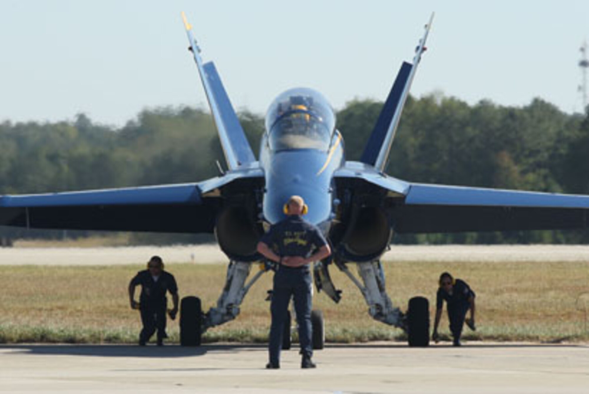 Blue Angel air crew technicians remove the wheel chocks before racing back to position during the ceremonial opening performance before take-off on Oct. 15. (U.S. Air Force Photo/Don Peek)