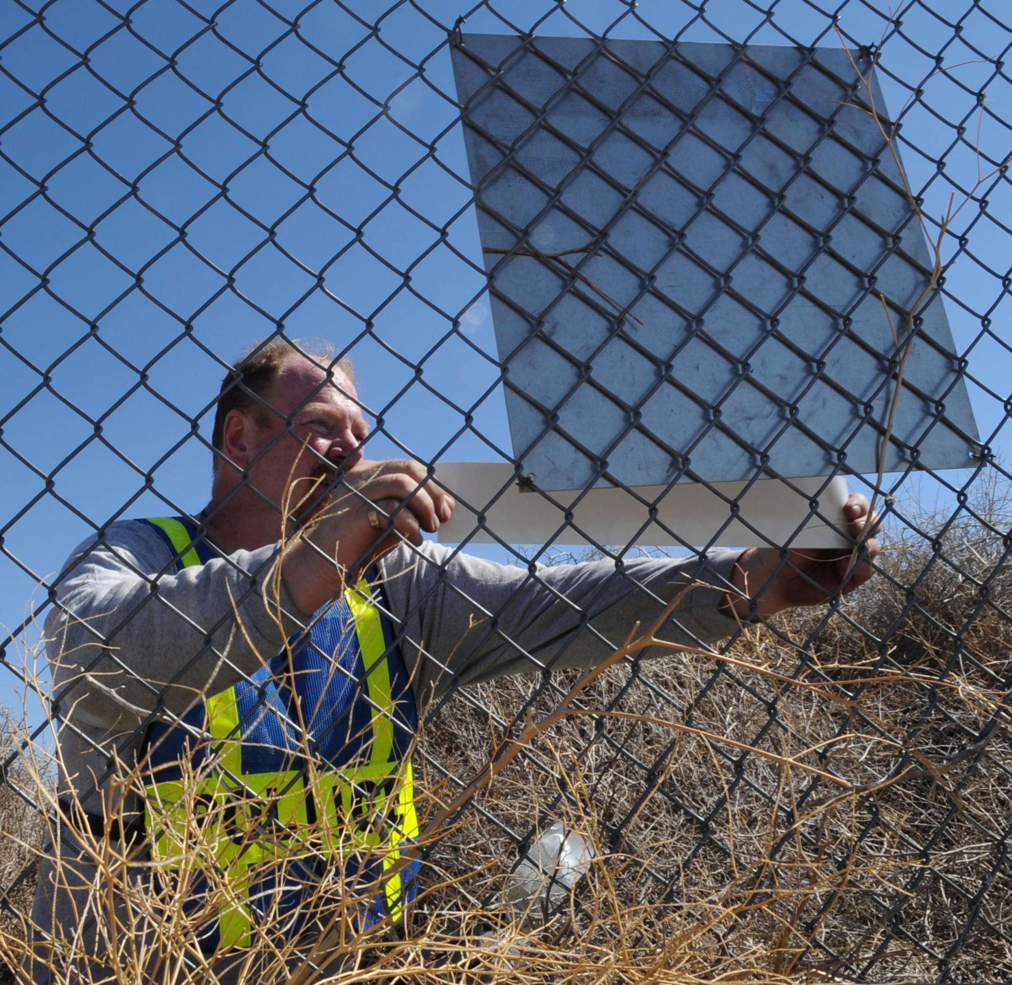 MOUNTAIN HOME AIR FORCE BASE, Idaho -- Shawn Roddin, Security Forces Squadron resource protection, places a Military Working Dog sticker on a sign Sep 23. Security forces provide integrated defense and law enforcement for the base and develop highly trained Airmen to support deployed contingency operations. (U.S. Air Force photo by Senior Airman Roy Lynch)