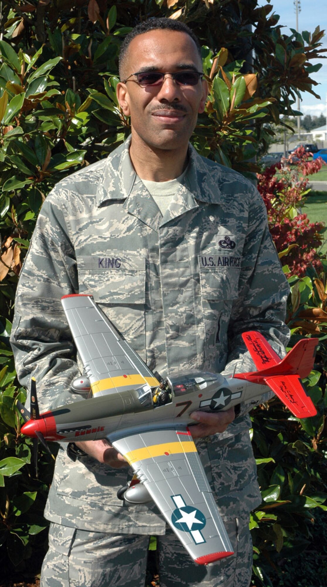 JOINT BASE LEWIS-MCCHORD, Wash., -- Master Sgt. Charles King, 446th Aircraft Maintenance Squadron, holds a replica of a P-51 Mustang that was flown by an original Tuskegee Airman, retired Capt. Roscoe Brown Jr.  Sergeant King purchased the model aircraft while at the 39th Tuskegee Airmen Conference in San Antonio, Texas earlier this year.  He was able to meet Captain Brown and have him sign the aircraft model, which now sits proudly in Sergeant King's office here.  Sergeant King is a member of the Seattle-area Sam Bruce Chapter of Tuskegee Airmen.  "Our main goal is to keep the legacy alive," he said. (U.S. Air Force photo/Staff Sgt. Grant Saylor)