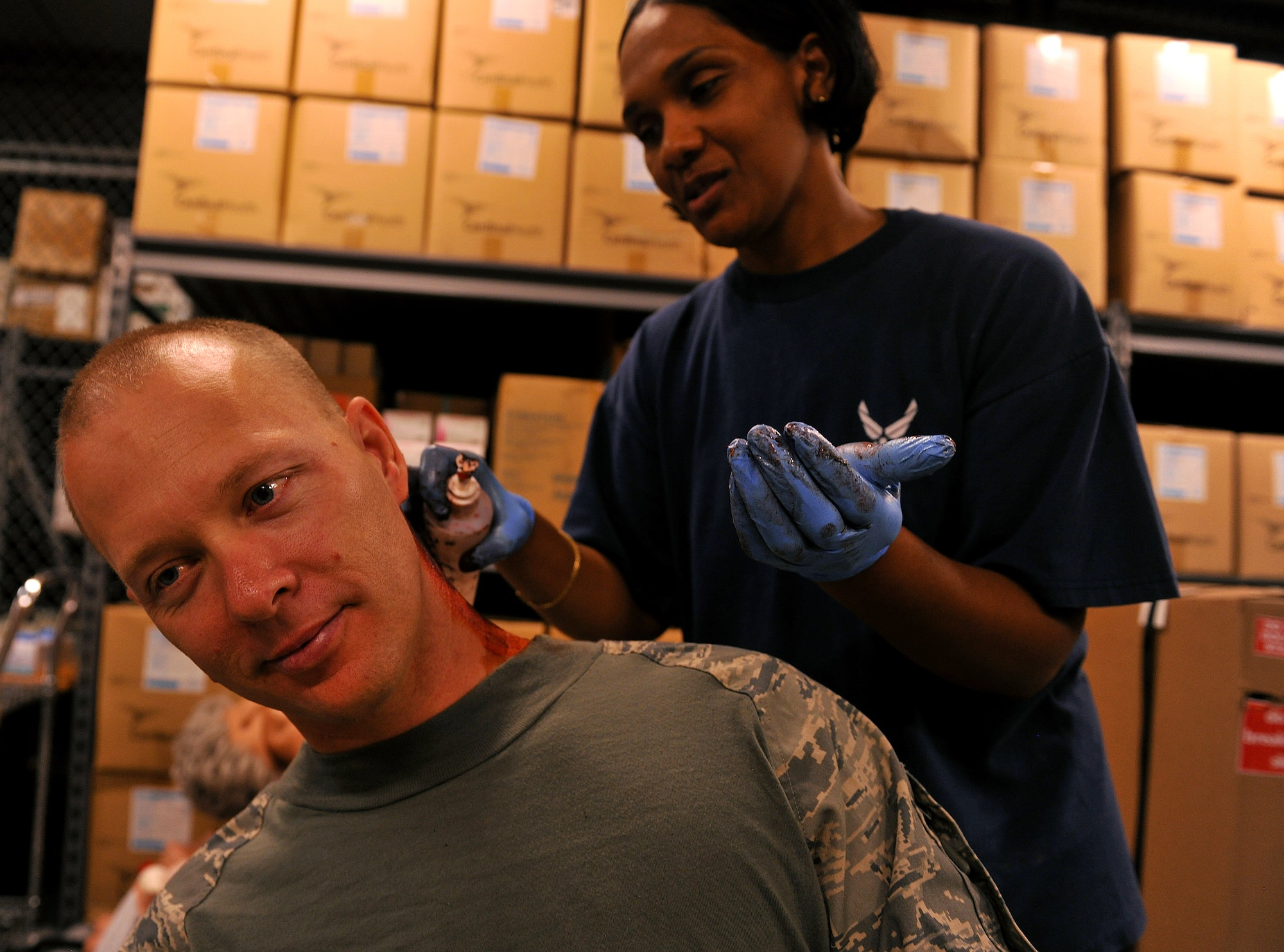 MOODY AIR FORCE BASE, Ga. -- Tech. Sgt. Carl Louk, 41st Rescue Squadron, sits and waits for Master Sgt. Matilda Mahone, 23rd Medical Support Squadron pharmacy flight chief, to apply moulage to his neck before a Major Accident Response Exercise here Oct. 15. The exercise required more than 100 volunteers to participate as victims in a simulated aircraft accident in preparation for the Community Appreciation Day Airshow Nov. 13. (U.S. Air Force photo/Airman 1st Class Joshua Green)
