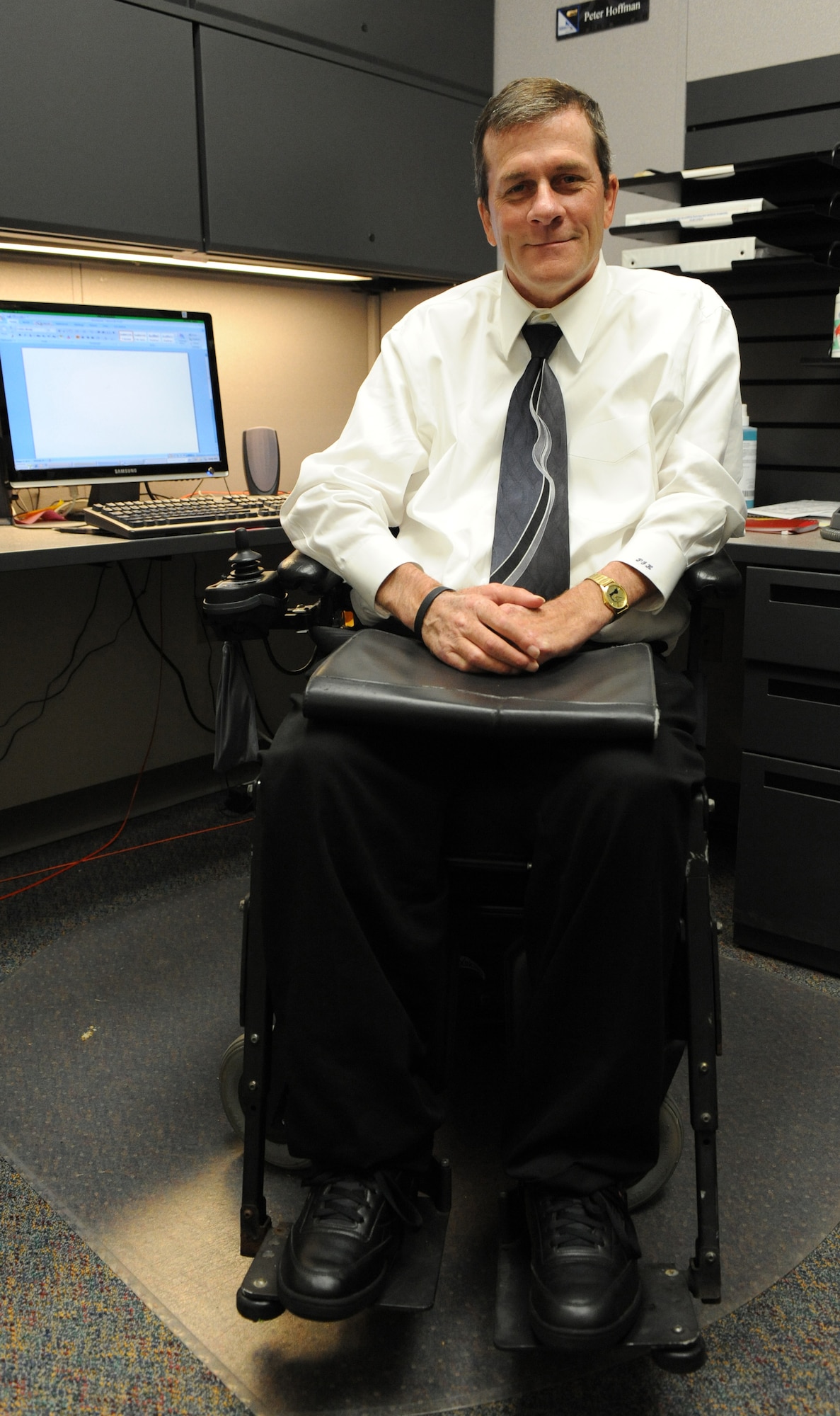 Peter Hoffman, 720th Special Tactics Group program analyst, poses by his work station at his group's headquarters building at Hurlburt Field, Fla., Oct. 15, 2010.  Mr. Hoffman, a quadriplegic, was hired by the 720th STG and became Hurlburt Field's first hire under a recent Presidential executive order directing an increase in hiring disabled people throughout the federal government. (DoD photo by U.S. Air Force Airman 1st Class Caitlin O'Neil-McKeown) (RELEASED)
