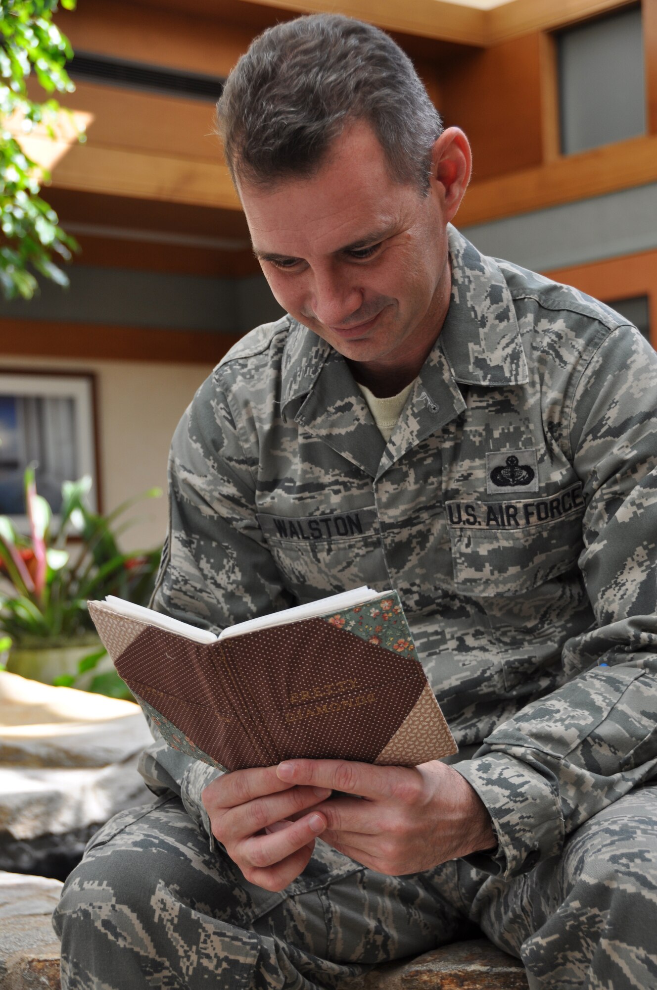 Senior Master Sgt. Dan Walston, Air Force Mortuary Affairs Operations Center, reads thank you letters from a quilted photo album he was given before his departure. Sergeant Walston is deployed to the mortuary from Langley Air Force Base, Va. He was presented a Quilt of Valor Oct. 14 for his service in returning America's fallen with dignity, honor and respect. The album accompanied the quilt and contained photos of and notes from quilters who make Quilts of Valor for wounded servicemen, veterans and those touched by war. More than 400 personnel from the Air Force Mortuary Affairs Operations Center have been presented quilts for their service and support of the fallen. (U.S. Air Force photo/Christin Michaud)