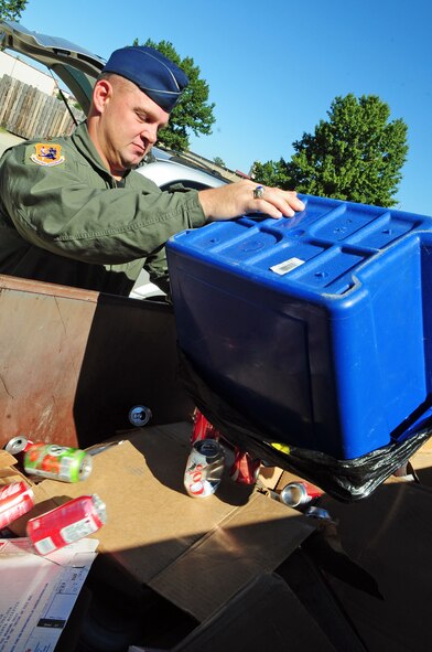 BARKSDALE AIR FORCE BASE, La. -- Maj. Jason Smith, 608th Air Operations Center, dumps his recyclables into a bin at the recycling center Oct. 15. The center, which recently began allowing additional items when it had previously only accepted high-grade paper and cardboard, now allows patrons to intermingle all items in the same bin without sorting. (U.S. Air Force photo/Senior Airman Joanna M. Kresge)