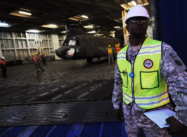 Chief Warrant Officer 2 Glen Simpson watches over a CH-47 and it's crew as it's off-loaded at the TC dock, Oct. 14, 2010, on Joint Base Charleston Weapons Station, S.C. The average travel time from over-seas to the U.S. for most cargo vessels is three weeks but can vary depending on weather and location of ports. CW2 Simpson is the mobility warrant officer and operations chief with the Army's 841st Transportation Battalion. (U.S. Air Force photo/Senior Airman Timothy Taylor)