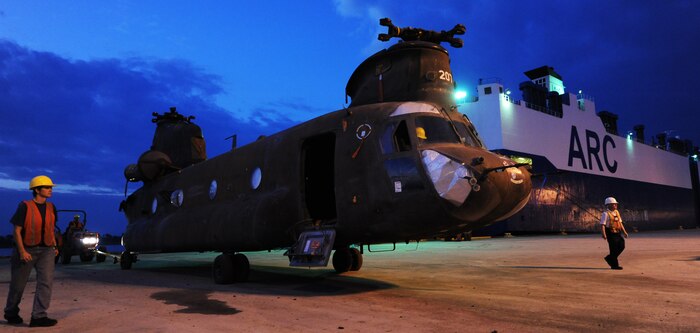 Civilian contractors spot for a driver as he tows a CH-47 helicopter to a temporary storage lot at the TC dock Oct. 14, 2010, on Joint Base Charleston-Weapons Station, S.C. The CH-47 Chinook's primary roles are troop movement, artillery emplacement and battlefield resupply and can travel at speeds above 155 miles per hour. (U.S. Air Force photo/Senior Airman Timothy Taylor) 
