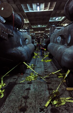 Civilian contractors detach CH-47 helicopters from the hull of a commercial cargo ship at the TC dock  Oct. 14, 2010, on Joint Base Charleston-Weapons Station, S.C. Contractors off-loaded eight CH-47 helicopters in just under two hours to be inspected and reassembled with blades and other parts for transportation. (U.S. Air Force photo/Senior Airman Timothy Taylor) 
