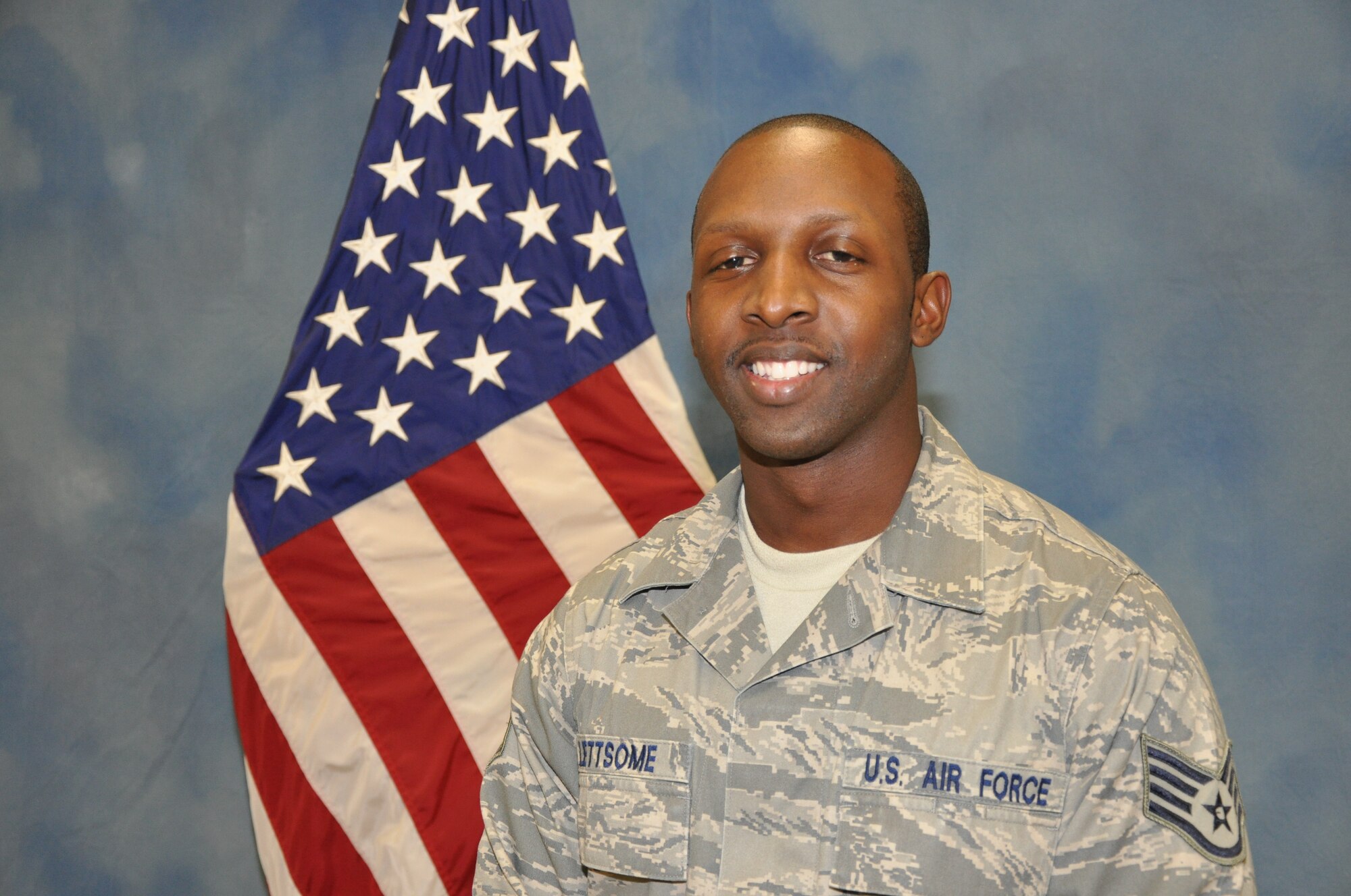 Staff Sgt. Sheldon Lettsome, 11th Intelligence Squadron geospatial analyst, poses in front of the American flag at the 1st Special Operations Wing photo lab at Hurlburt Field, Fla., Oct. 14, 2010. Sergeant Lettsome was selected for this week's Tip of the Spear spotlight. (DoD photo by U.S. Air Force Airman 1st Class Joe McFadden) (RELEASED) 
