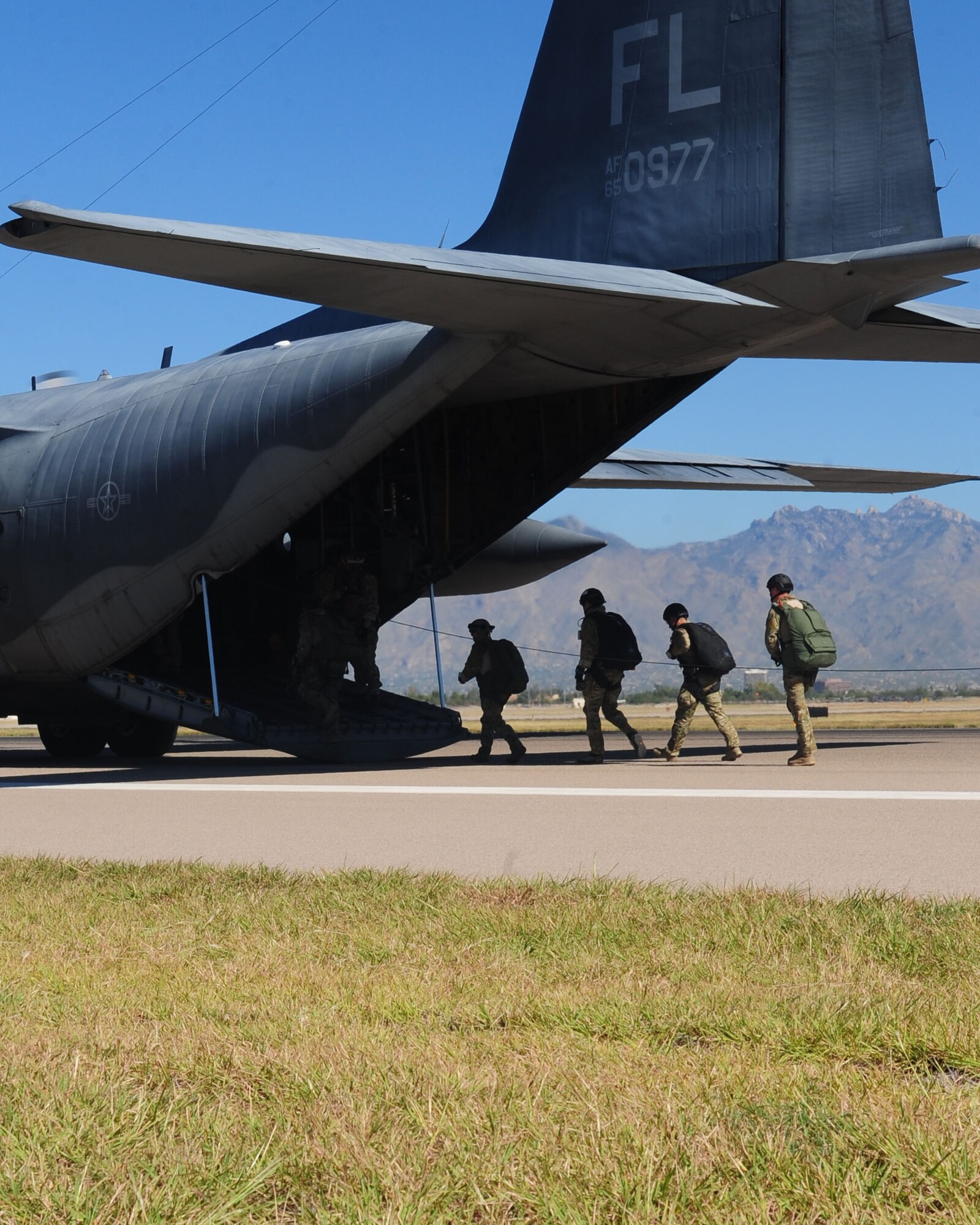 DAVIS-MONTHAN AIR FORCE BASE, Ariz. - Pararescuemen participating in the bi-annual PJ Rodeo competition, board a C-130 Hercules on the flightline here Oct. 9, 2010. The C-130 transported the PJ’s to their drop zone where they executed a parachuting challenge which evaluated their ability to hit a predetermined target. Established in 2004, the week-long competition simulates real world scenarios testing the core skill sets of each team which included trauma medicine, military free-fall and static-line parachuting, rifle and pistol marksmanship, and field/survival skills while working to foster teamwork and esprit de corps among the entire Guardian Angel community. (U.S. Air Force photo/Airman 1st Class Jerilyn Quintanilla)