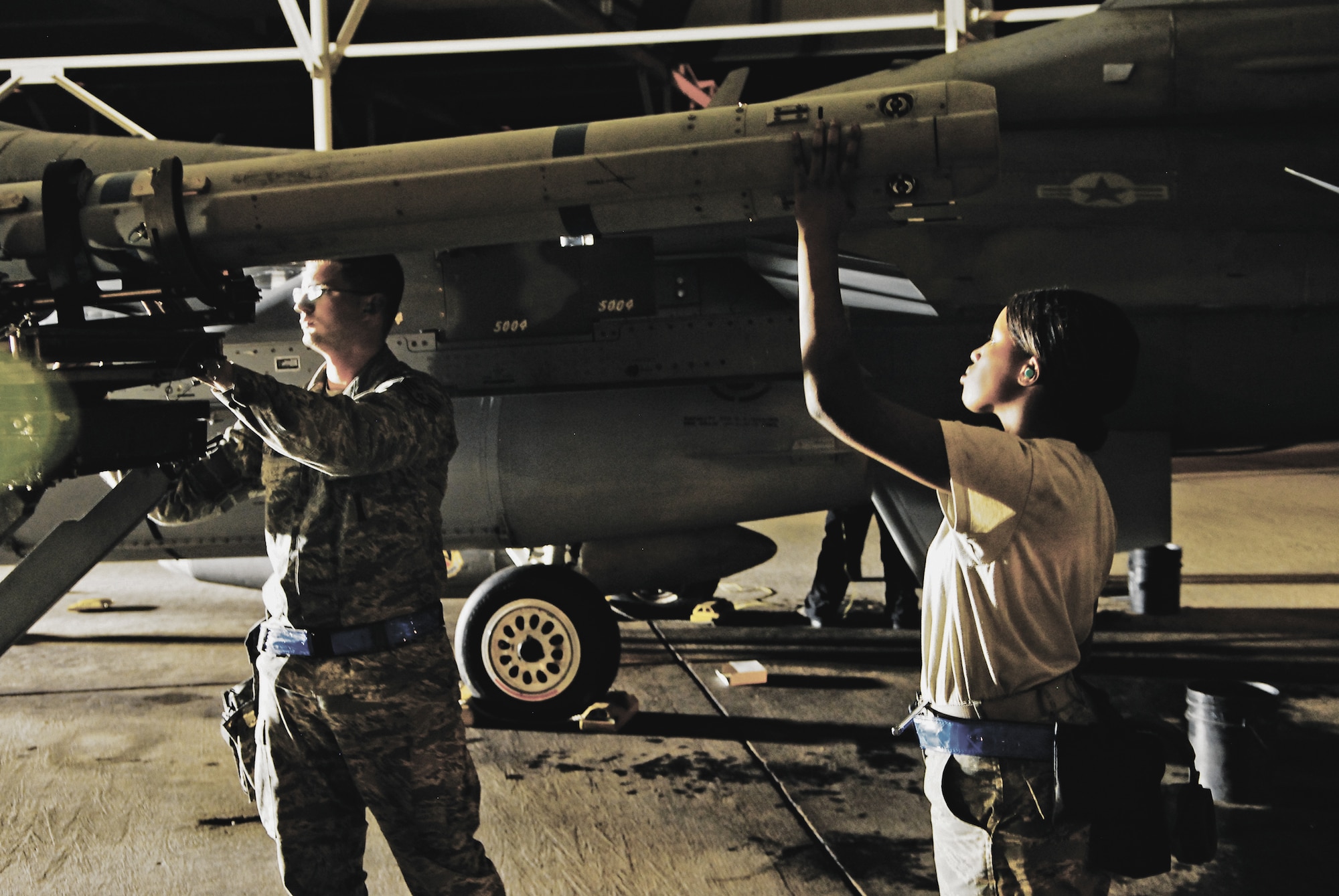 Staff Sgt. Earl Leithead, 756th Aircraft Maintenance Squadron crew chief, and Airman 1st Class Genesa Williams, 756th Aircraft Maintenance Squadron weapons crew member, line up a missile for loading in preparation for the next day's flight.  Crew cheifs work at night to prepare jets for the next day's missions and perform maintenance that there is no time to complete during the day. (U.S. Air Force photo/Senior Airman C.J. Hatch)
