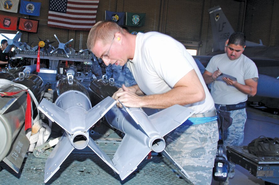 Senior Airman Joshua Chapman, 309th Fighter Squadron, performs an inspection on the MK-82 low drag bomb and shouts out imperfections to Staff Sgt. Michael Aviles, 756th Aircraft Maintenance Squadron, as he records on the checklists during the load crew competition on October 8th.  (U.S. Air Force photo/Staff Sgt. Steve Nabor)