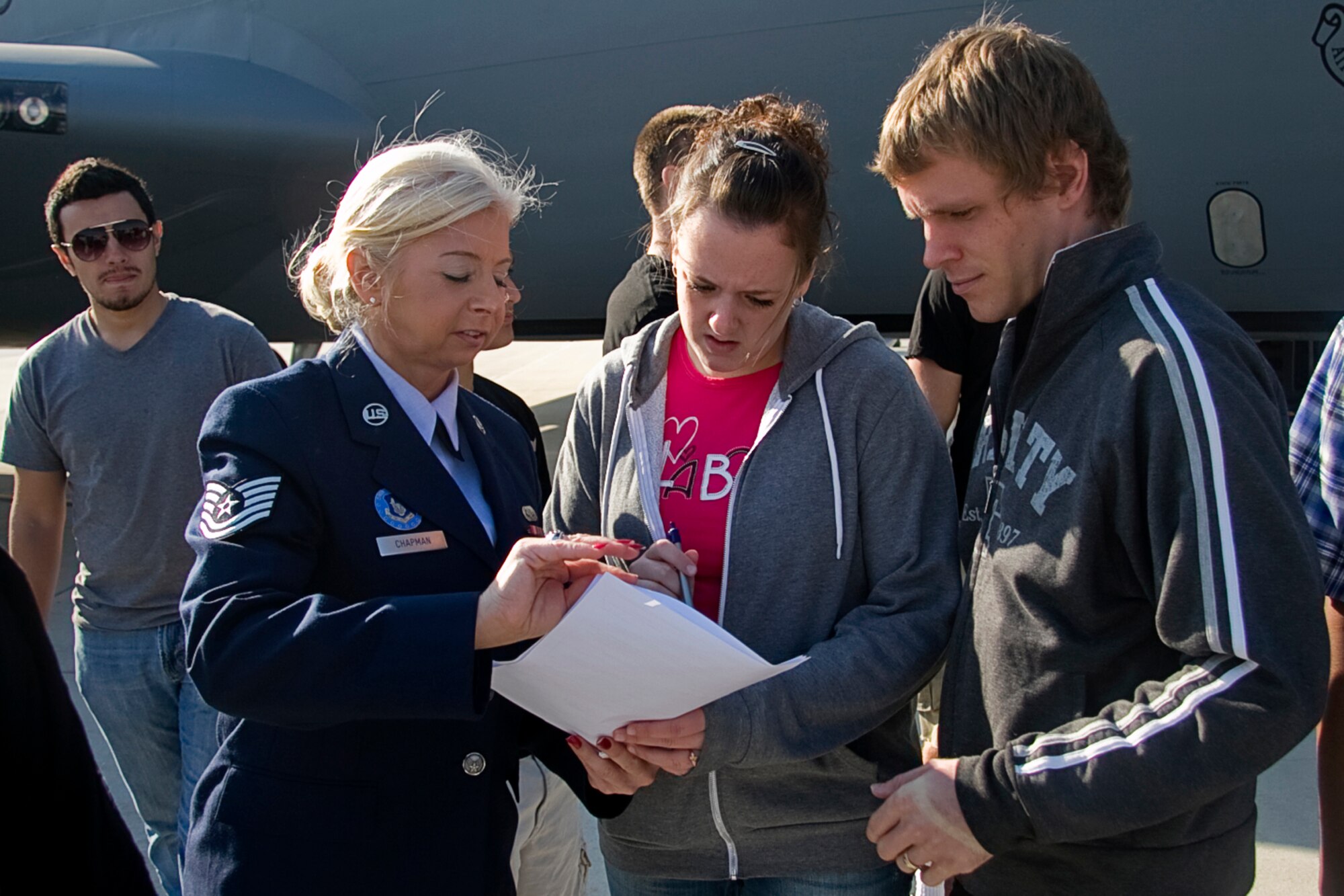 GRISSOM AIR RESERVE BASE, Ind. -- Tech. Sgt. Constance Chapman, an Air Force Reserve recruiter, gives enlistment paper work to Craig and Corina Garrison shortly after they both raised their hands and took their oath of enlistment Oct. 12. The Garrisons, who are married, decided to join the Air Force Reserve together and will be leaving for basic military training at the same time. The couple enlisted with several other recruits at Grissom shortly before taking off on one of 434th Air Refueling Wing's KC-135s to witness the an aerial refueling mission. (U.S. Air Force photo/Tech. Sgt. Mark R. W. Orders-Woempner)