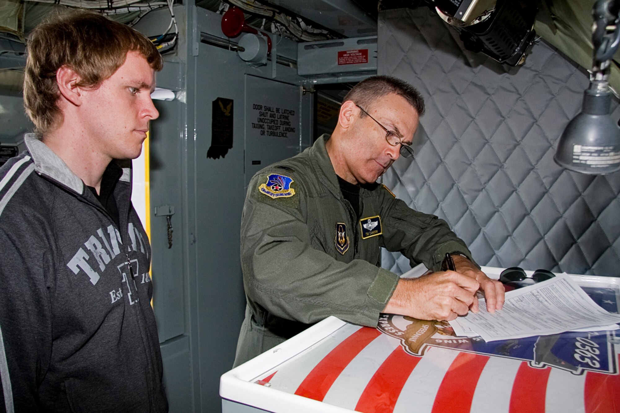 GRISSOM AIR RESERVE BASE, Ind. -- Craig Garrison waits patiently as Col. William T. "Tim" Cahoon signs his enlistment paperwork on board a KC-135R Stratotanker here Oct. 12. A group of Air Force Reserve recruits enlisted in front of one of 434th Air Refueling Wing's KC-135s here shortly before taking off on their first Air Force flight to witness the an aerial refueling mission. Colonel Cahoon is the 434th ARW commander. (U.S. Air Force photo/Tech. Sgt. Mark R. W. Orders-Woempner)