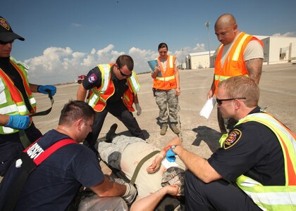 Members of the San Antonio Fire Department secure a simulated casualty to a litter during a major accident and response exercise Oct. 12. The SAFD joined the 59th Medical Wing, the 502nd Air Base Wing and the 37th Training Wing for the exercise to ensure emergency responders and prepared for AirFest 2010. (U.S. Air Force photo/Robbin Cresswell)