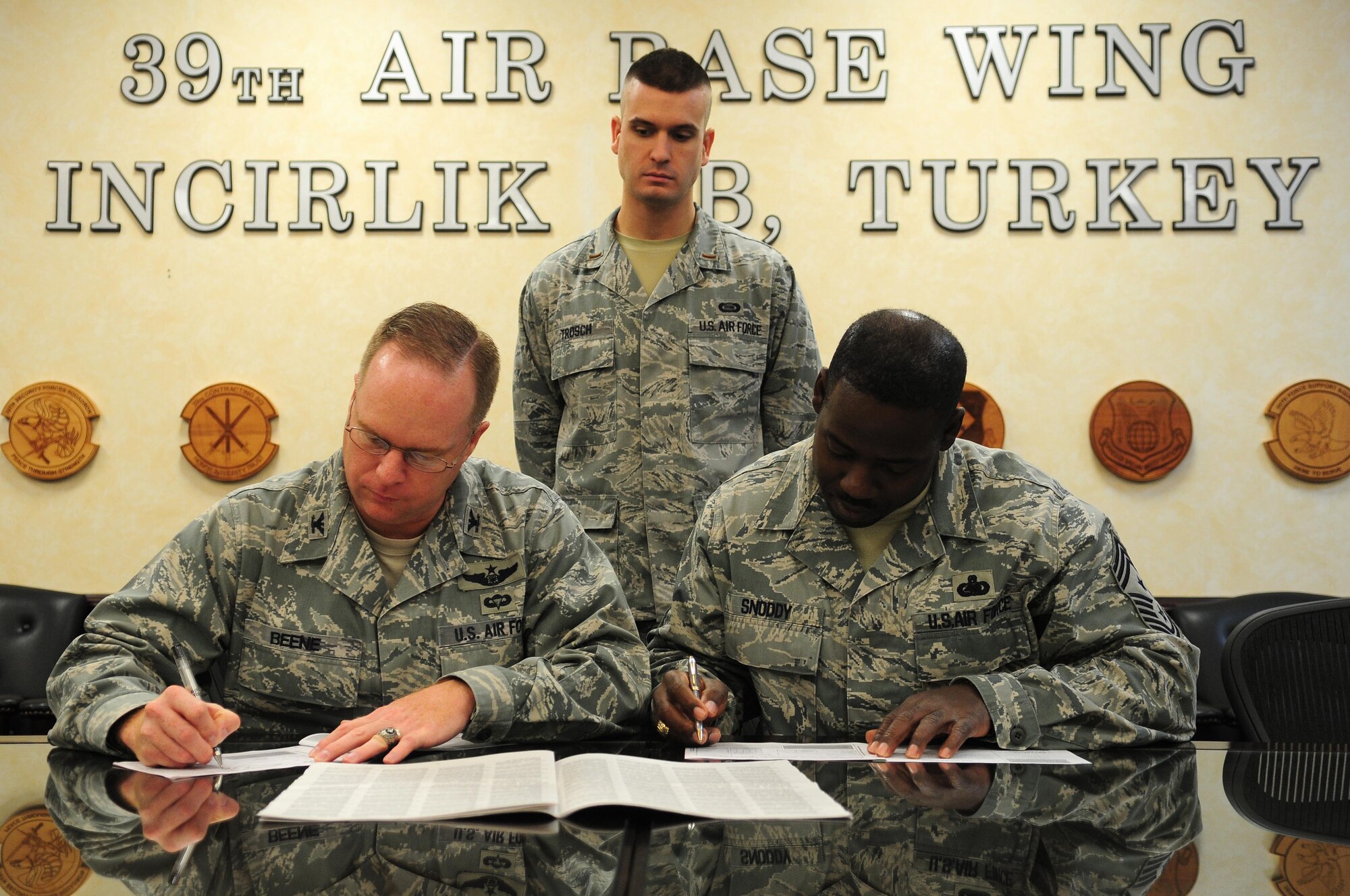 2nd Lt. Harry Trosch, 39th Air Base Wing Combined Federal Campaign manager, assists Col. Eric Beene, 39th ABW commander, and Chief Master Sgt. Marcus Snoddy, 39th ABW command chief, as they fill out 2010 CFC donation forms Oct. 15, 2010 at Incirlik Air Base, Turkey.  The CFC is the only authorized solicitation of federal employees in their workplaces on behalf of approved charitable organizations.  For more information on how to contribute, contact your unit CFC representative or visit www.cfcoverseas.org.  (U.S. Air Force photo by Senior Airman Ashley Wood/Released)