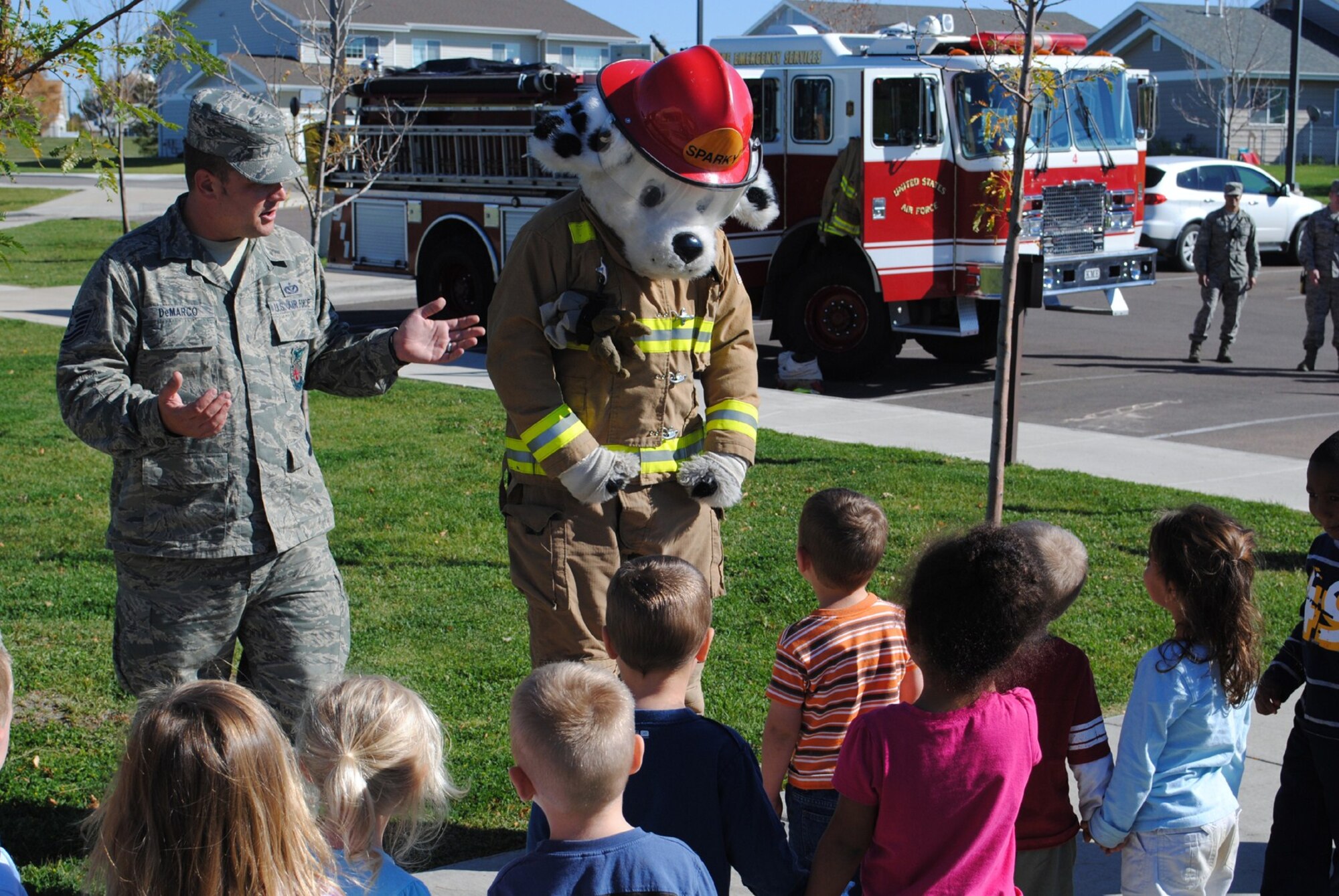 Tech. Sgt. Gregory DeMarco, 341st Civil Engineer Squadron firefighter, and “Sparky” the fire dog share some fire safety tips with children from the toddler class during a fire education display at the Child Development Center Oct. 6 for Fire Prevention Week.  (U.S. Air Force photo/Airman 1st Class Kristina Overton)