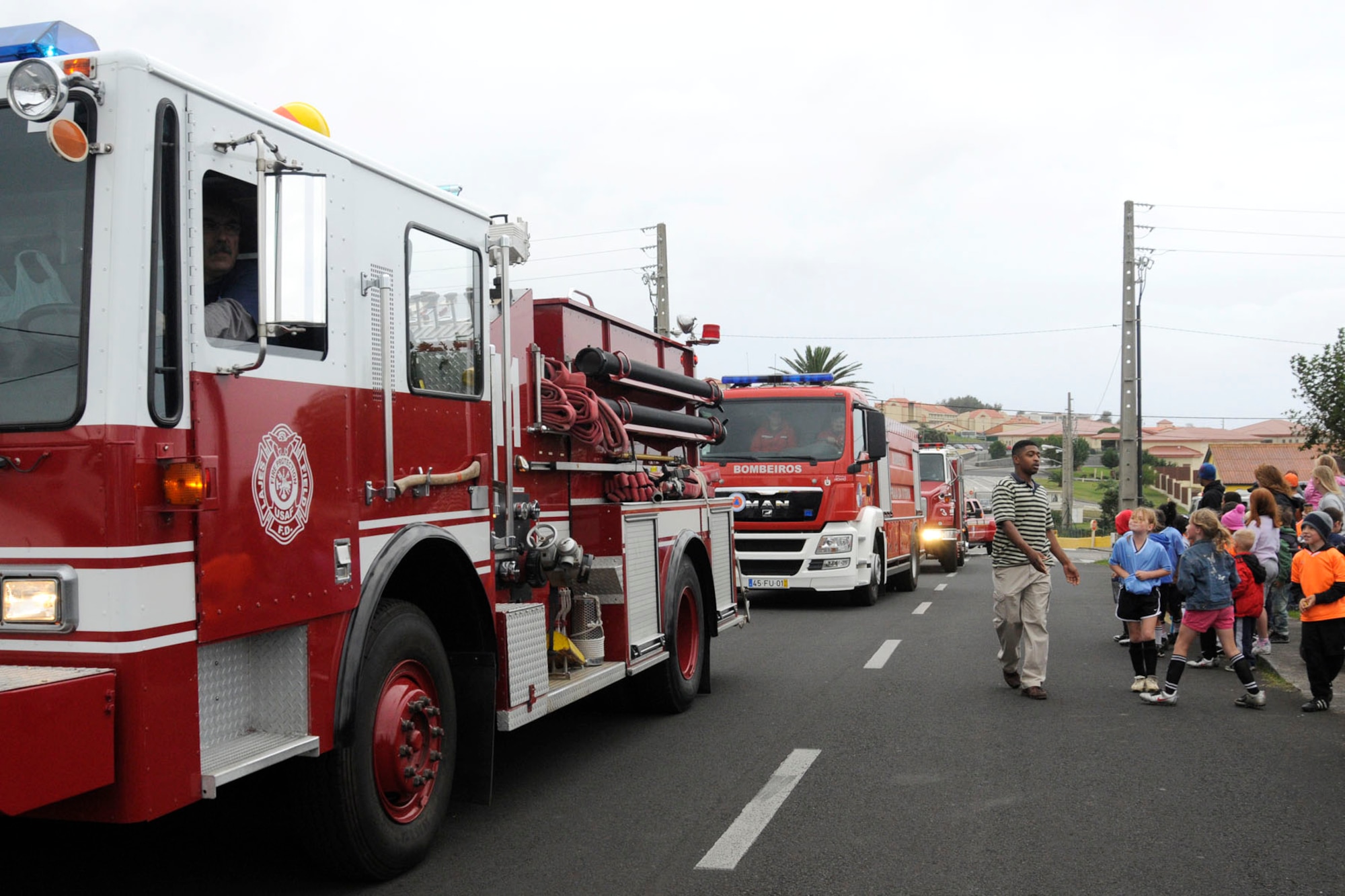 Team Lajes members watch fire response vehicles drive through Lajes Field as part of the base’s Fire Prevention Week Parade Oct. 9, 2010.  The parade showcased the variety of equipment that enables the 65th Civil Engineer Squadron to support the base’s mission and achieve the wing’s priorities.  (Photo by Tech. Sgt. Chyrece Campbell)